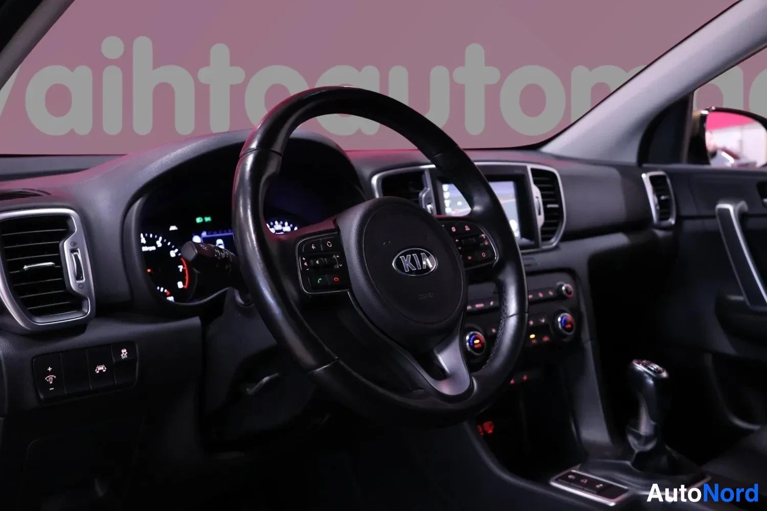 Muu: Auton ohjaamon etuosa: KIA-merkkinen ohjauspyörä, kojelaudan mittaristo ja infotainment-näyttö.