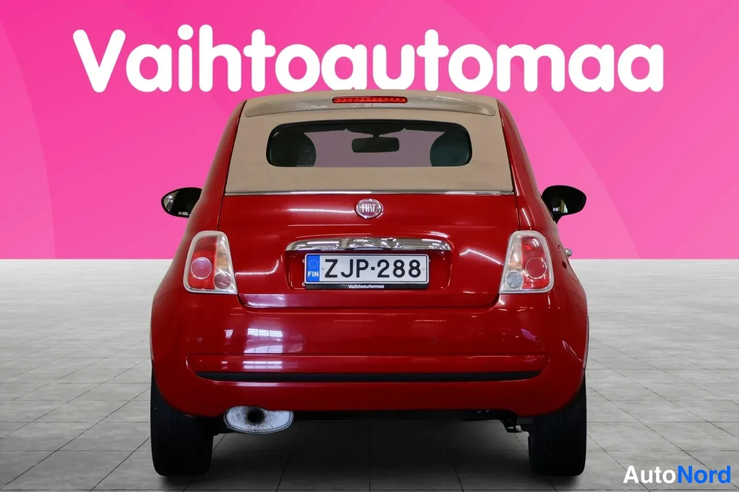 Takaa: Punaisen Fiat 500C:n suora takanäköymä beigeen pehmeään kattoon, rekisteritunnus, pakoputki näkyvissä.
