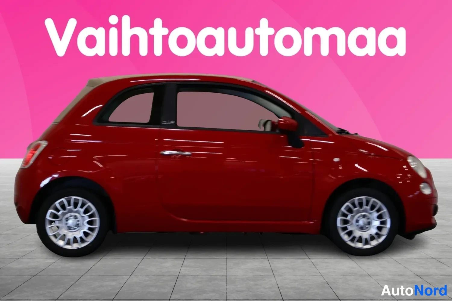 Sivulta: Punaisen Fiat 500C:n sivuprofiili avattavalla beige-katokkeella ja hopeavanteilla.