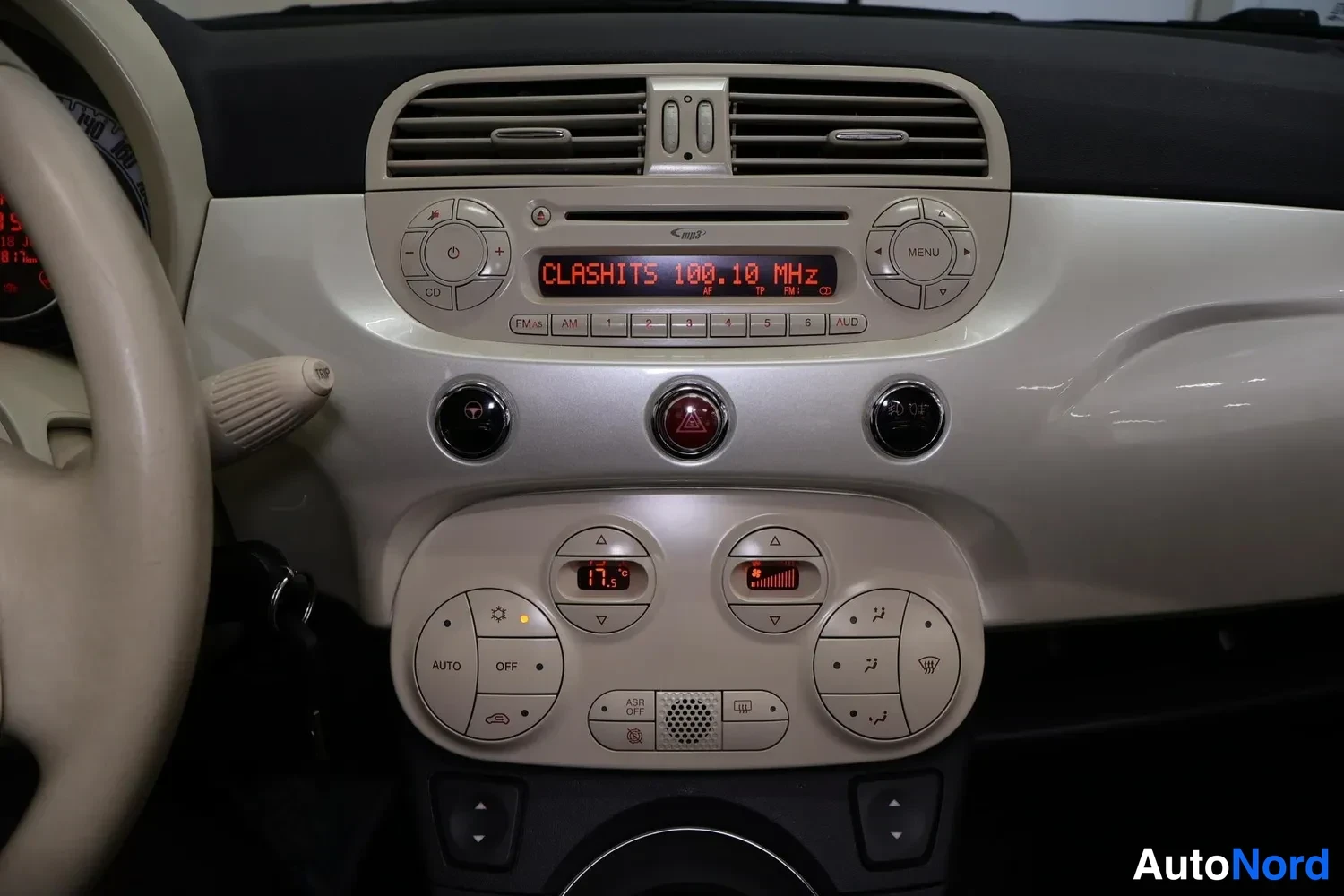 Muu: Kojelaudan keskikonsoli: radio näyttää CLASHITS 100.10 MHz, CD-asema, kierrätysnapit ja automaattinen ilmastointipaneeli.