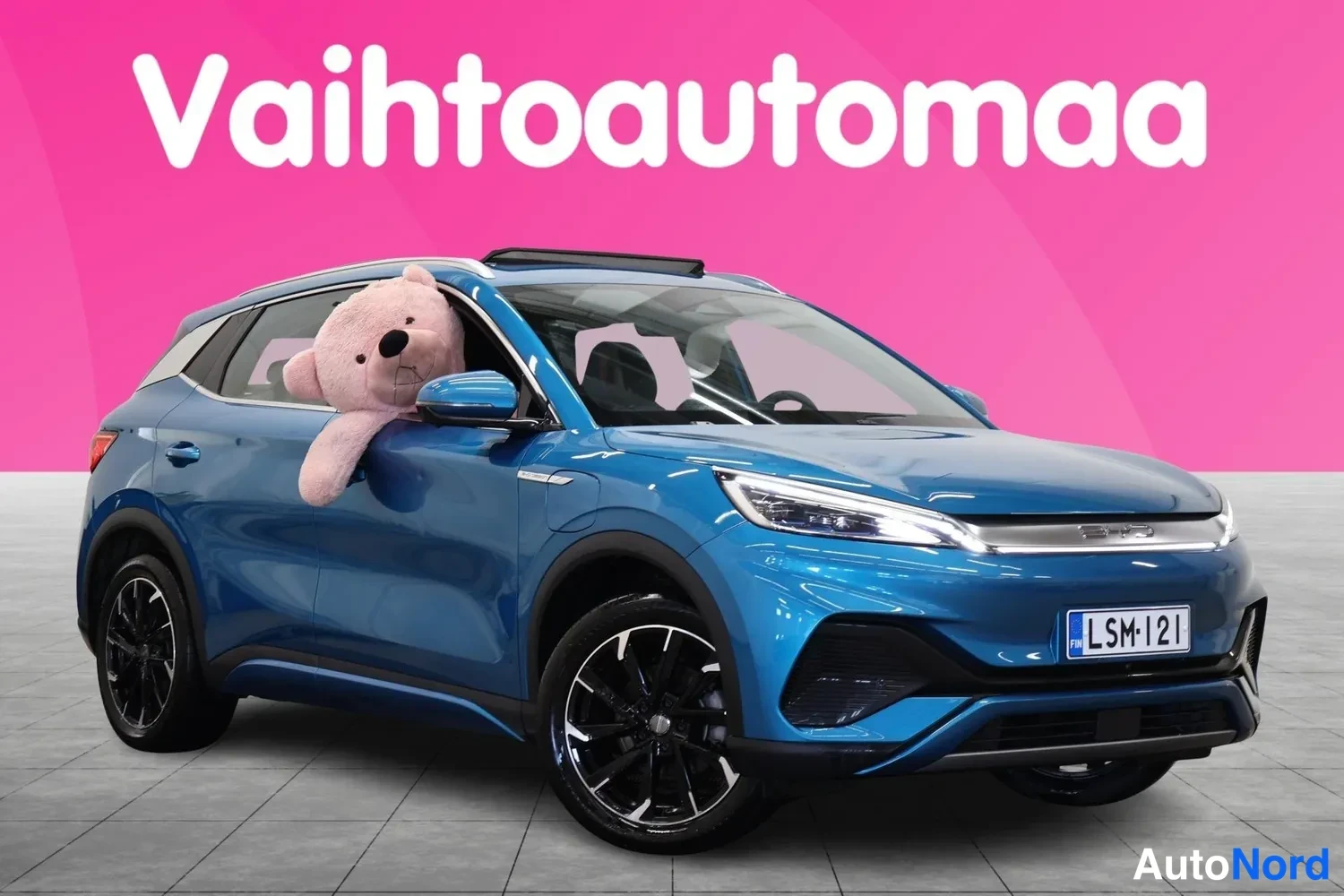 Etuviisto, nokka oikealle: Sininen BYD Atto 3 -maasturista kolmivartalokuva etukulmasta oikealta, rekisterikilpi, panoramic-kattoikkuna näkyvissä.