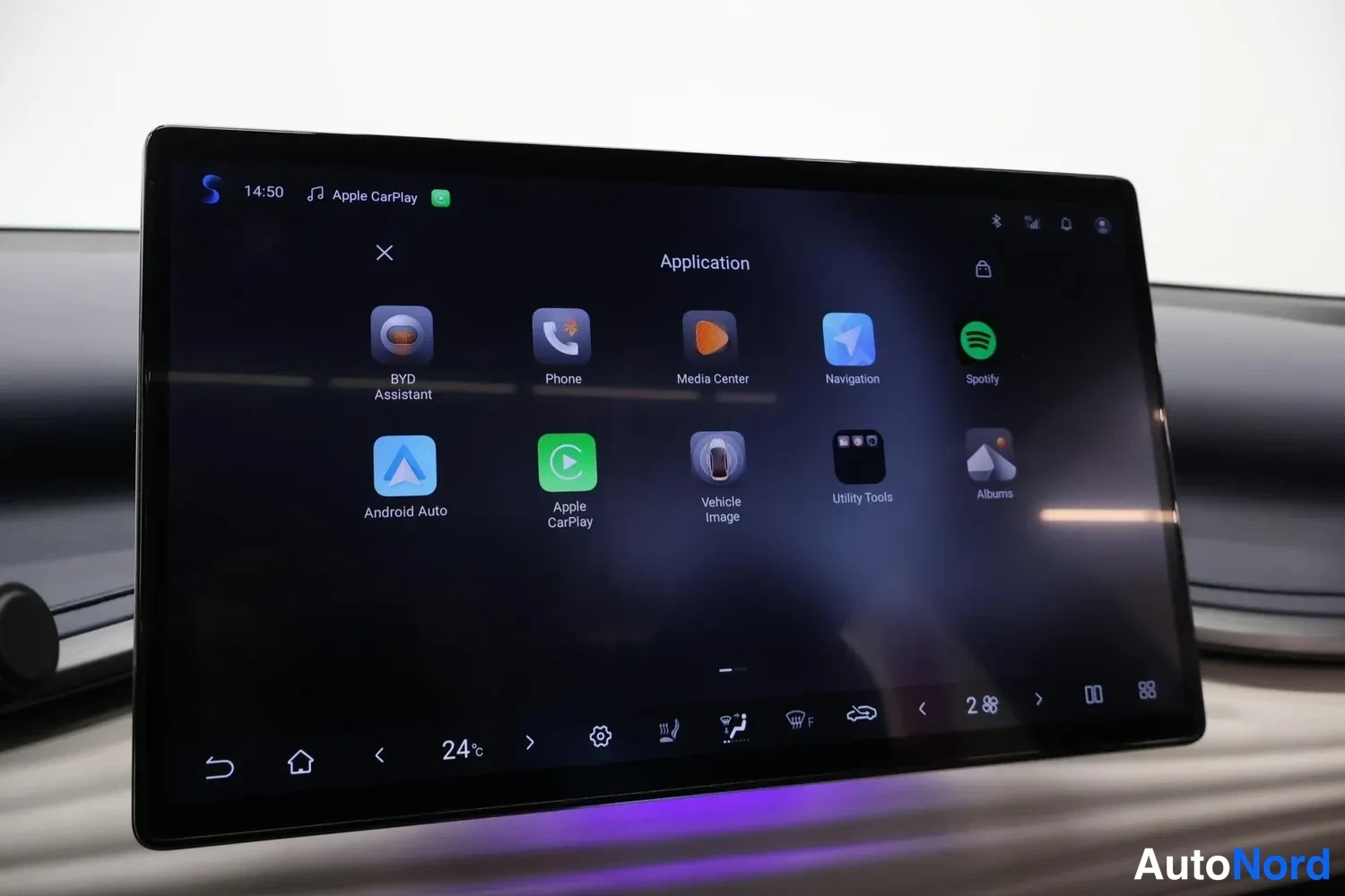 Yksityiskohta: Multimediajärjestelmän sovellusvalikko, jossa näkyvät mm. Android Auto, Apple CarPlay, Spotify, Navigaatio ja BYD Assistant.