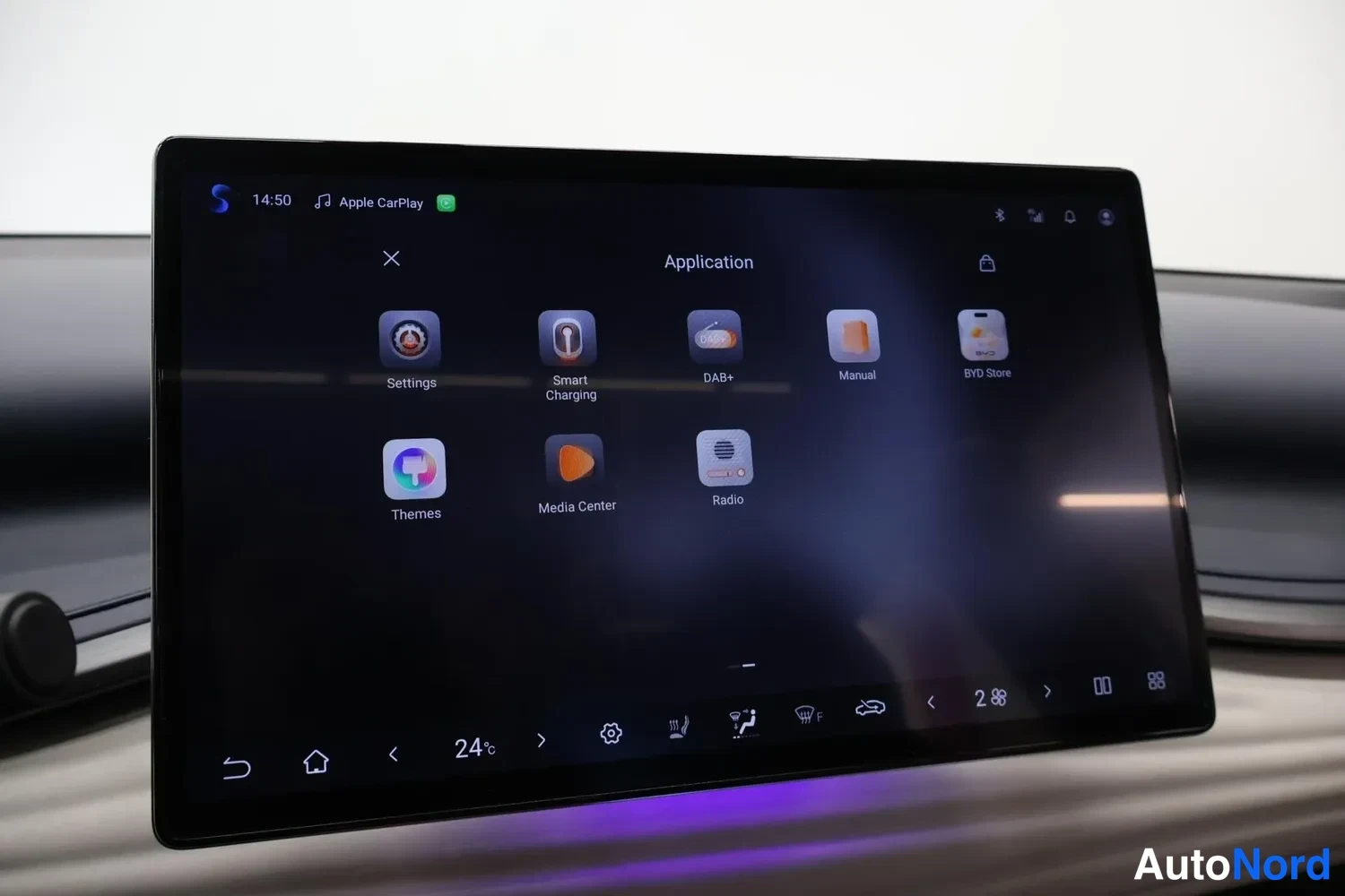 Yksityiskohta: Multimediajärjestelmän sovellusvalikko, jossa näkyvät mm. Settings, Smart Charging, DAB+, Manual, Themes, Media Center ja Radio.
