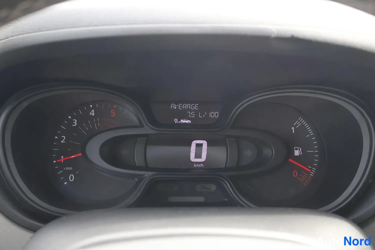 Muu: Renaultin kojelauta: nopeusmittari näyttää 0 km/h, keskiarvo 7,5 l/100 km, polttoaineneula punaisella alueella.
