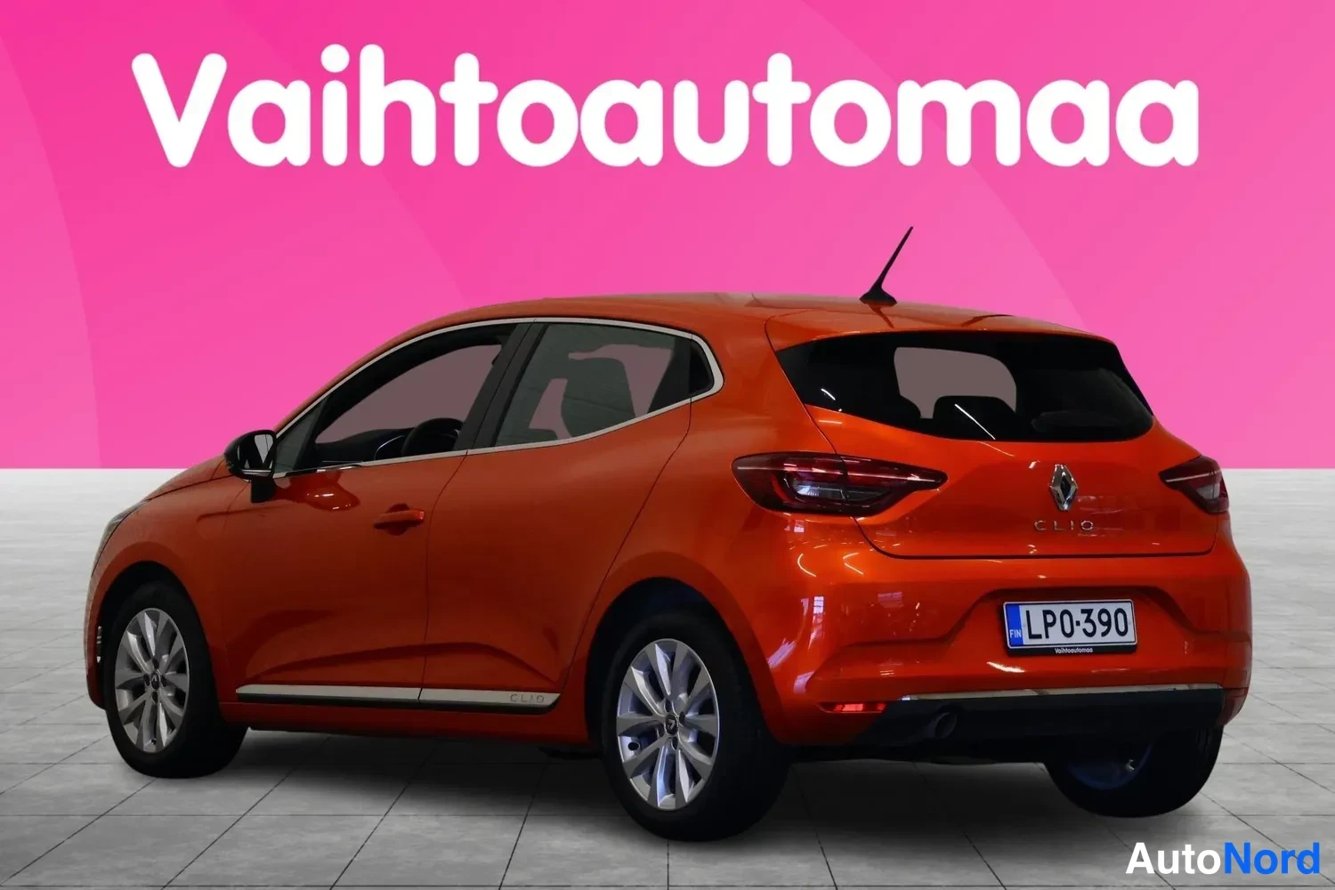 Takaviisto: Oranssinsuuntaisella maalilla oleva Renault Clio -henkilöauto takaa vasemmasta kulmasta kuvattuna.