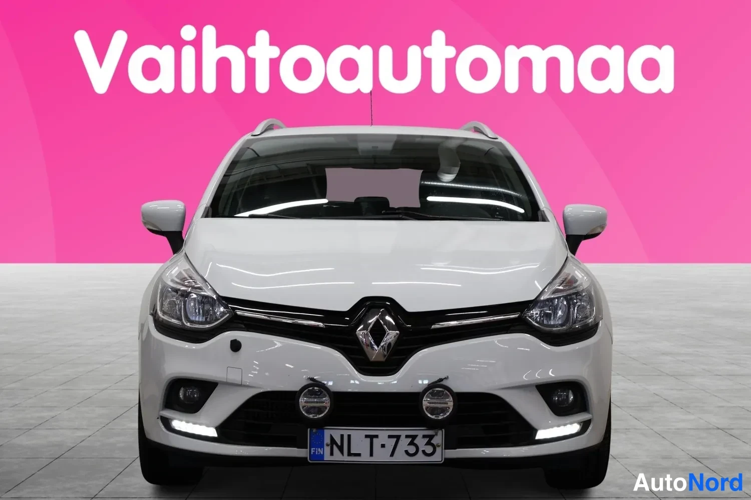Edestä: Valkoisen Renault Clion etunäkymä edestä, rekisteritunnus.