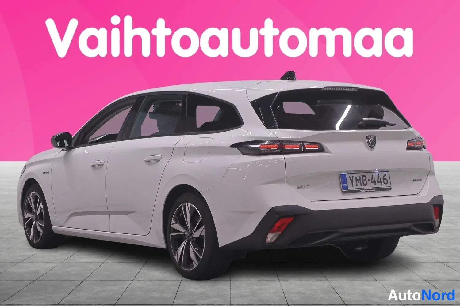 Takaviisto: Peugeot 308 -asema-auto valkoisena takavasemmalta kolmannesnäkymästä, rekisteritunnus.