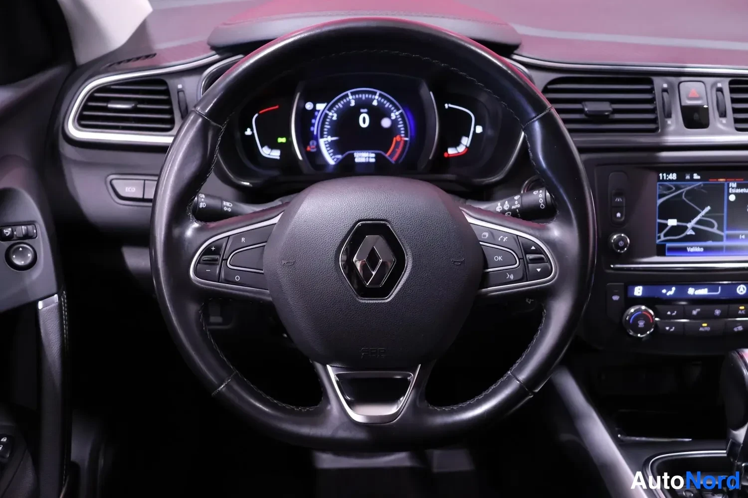 Muu: Renault-merkitty ohjauspyörä ja digitaalinen mittaristo lähikuvassa.