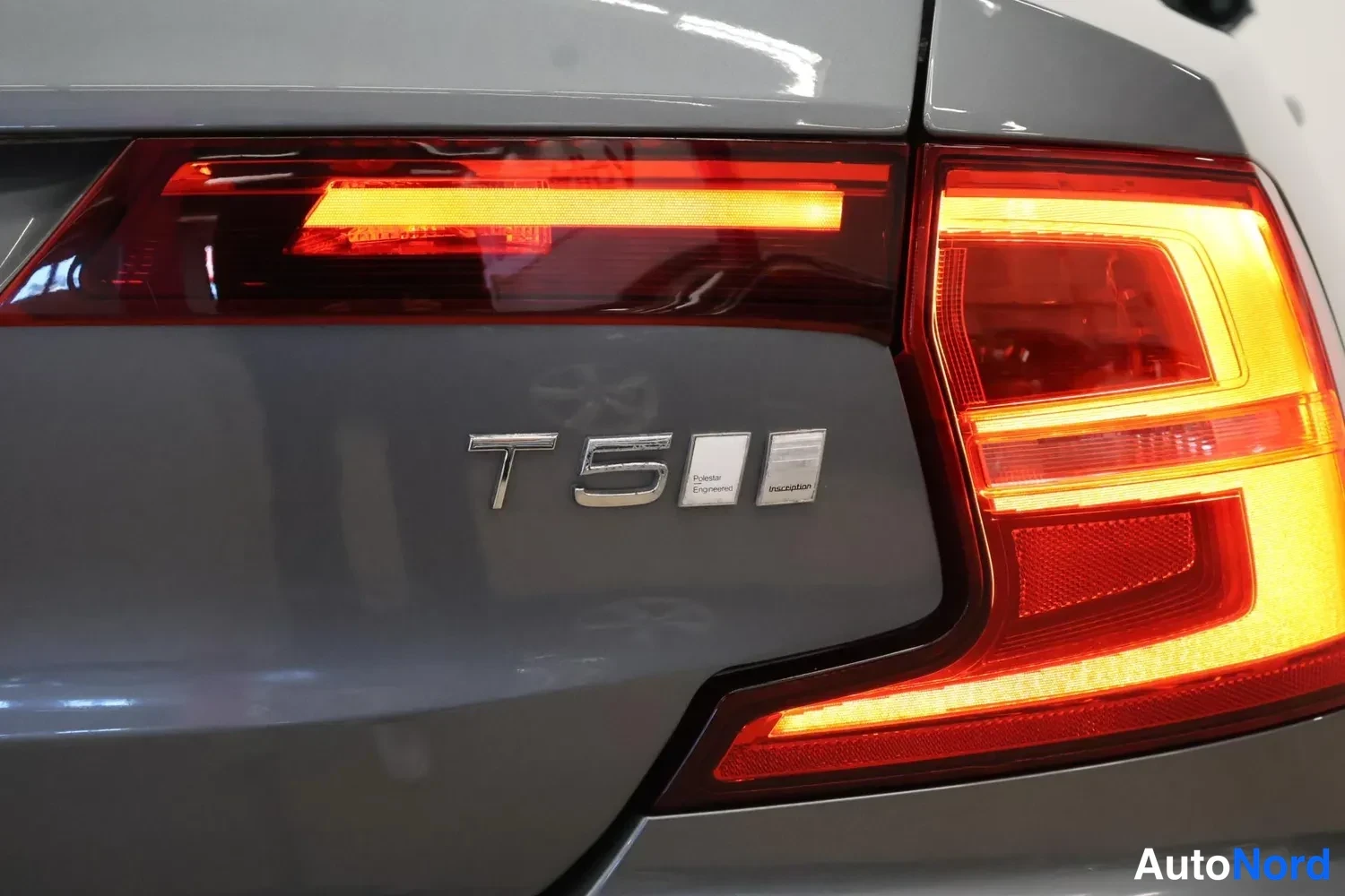 Takaa: Lähipikuva auton perästä, jossa näkyvät T5-merkintä, heated ja inscription -merkit sekä punainen takavalo.