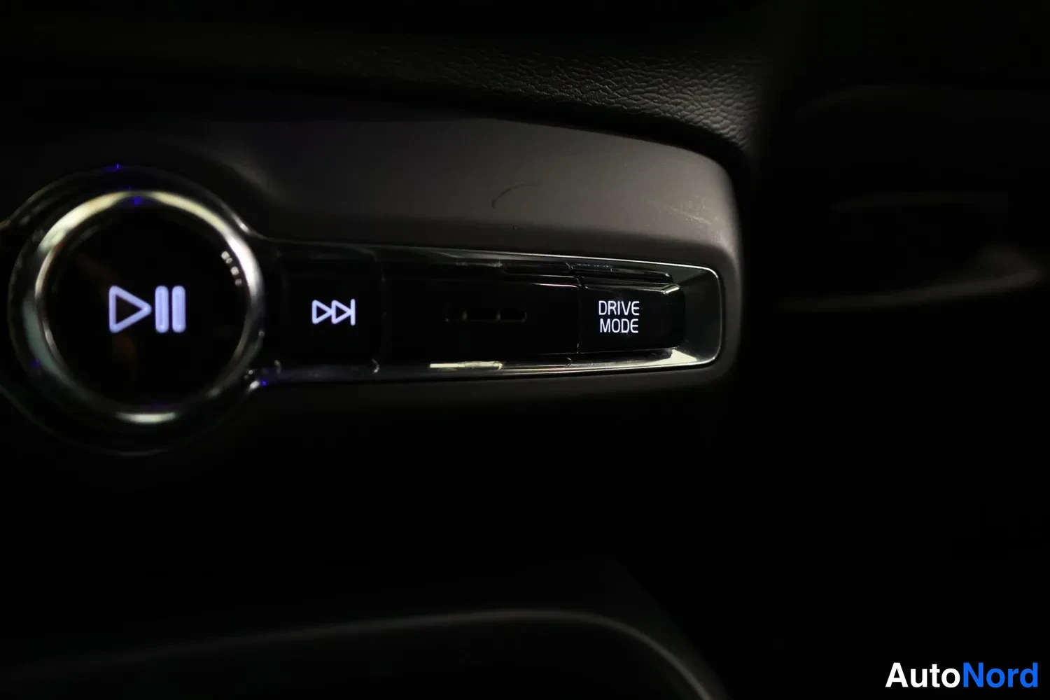 Yksityiskohta: Keskikonsolin näppäimet: toisto/pysäytys, DRIVE MODE ja rulla.
