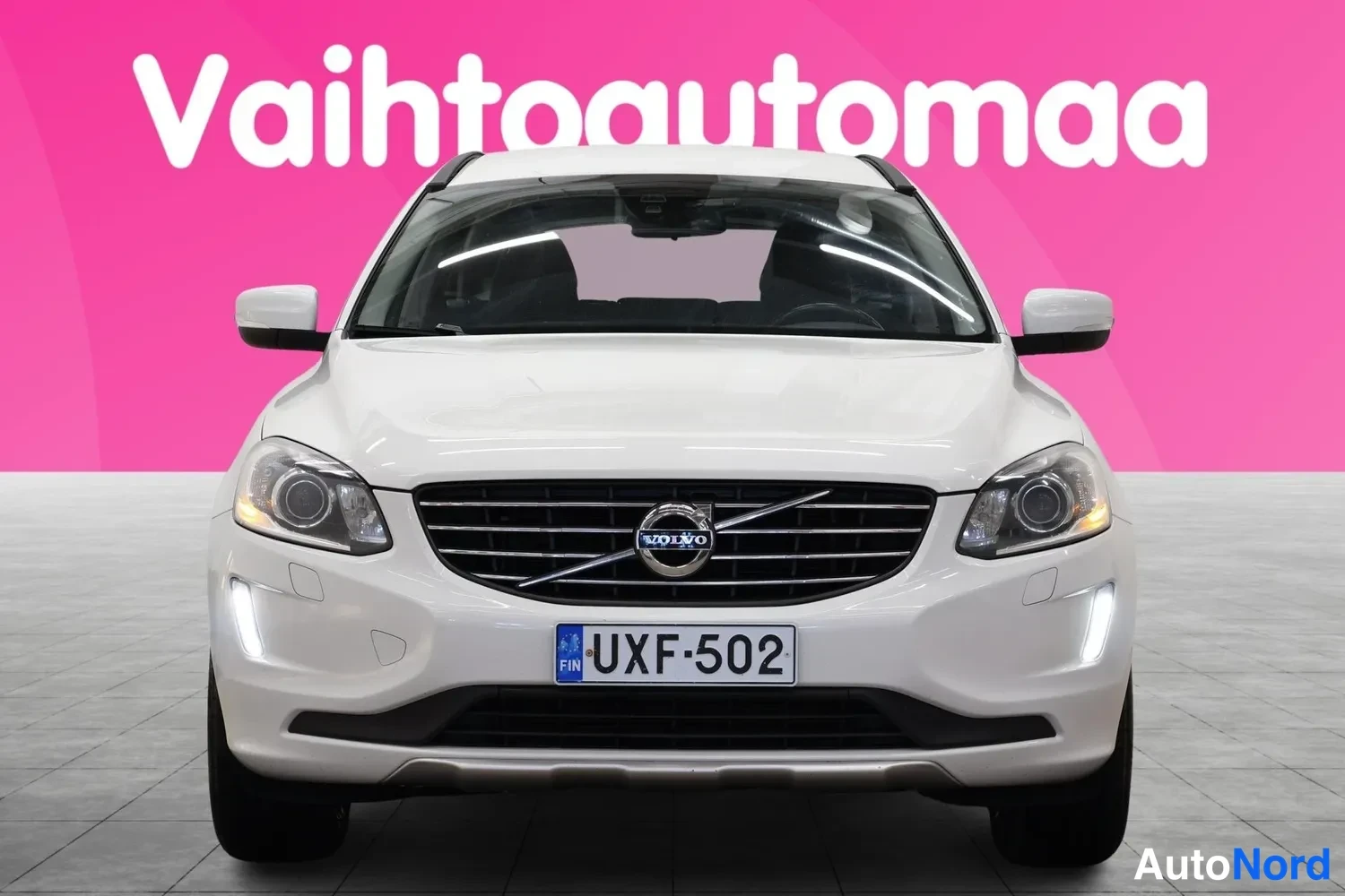 Edestä: Valkoinen henkilöauto suoraan edestä kuvattuna, rekisteritunnus.