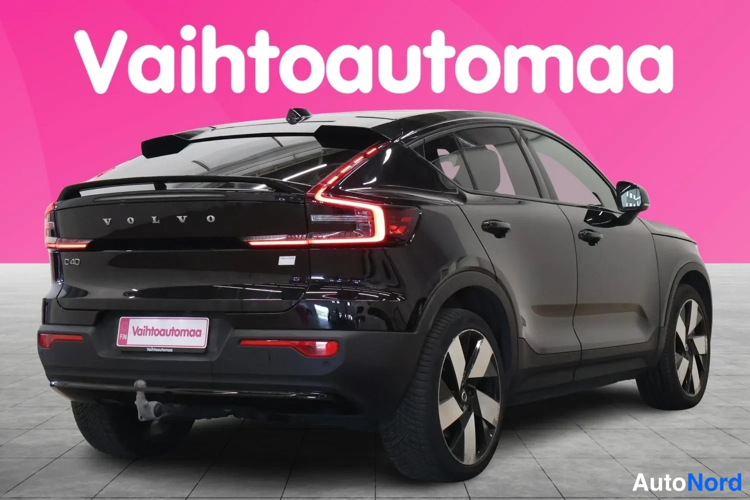 Takaviisto: Takaoksasuunta musta Volvo C40: takavalot, rekisteritunnuspalkki, mustat koripaneelit ja kaksiväriset vanteet näkyvät.