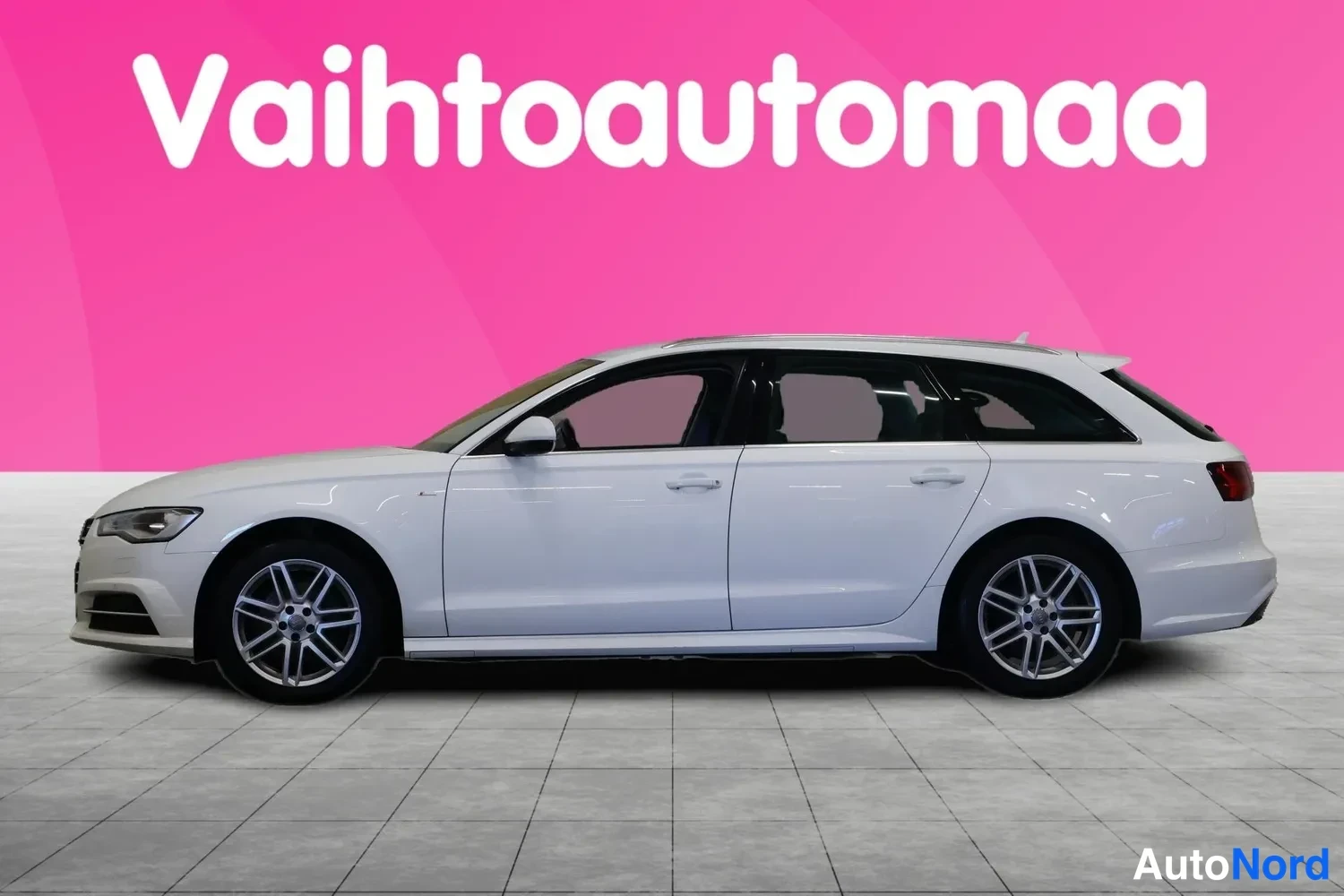 Sivulta: Valkoinen Audi A6 Avant -farmari sivusta kuvattuna