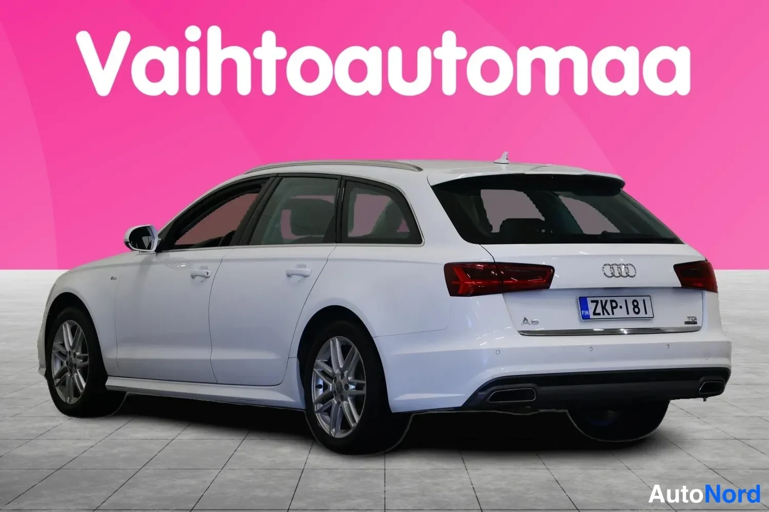 Takaviisto: Valkoisen Audi A6 Avant -farmarin takakulma vasemmalta