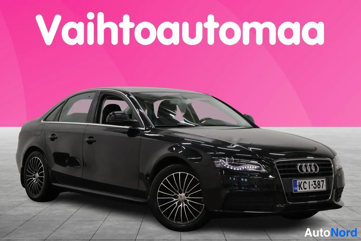 Etuviisto, nokka oikealle: Musta Audi A4 -sedan kolmen neljäsosan etunäkymässä, keula oikealla, vaaleilla alumiinivanteilla ja rekisteritunnuksella KC I-387.
