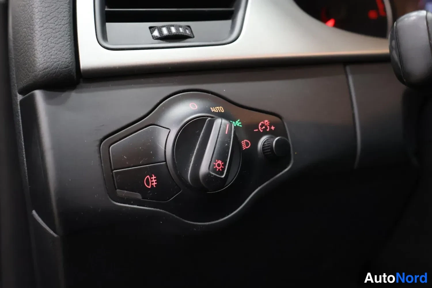 Muu: Lähikuva valokatkaisijasta kojelaudassa, jossa AUTO-asento ja sumuvalojen symboli.