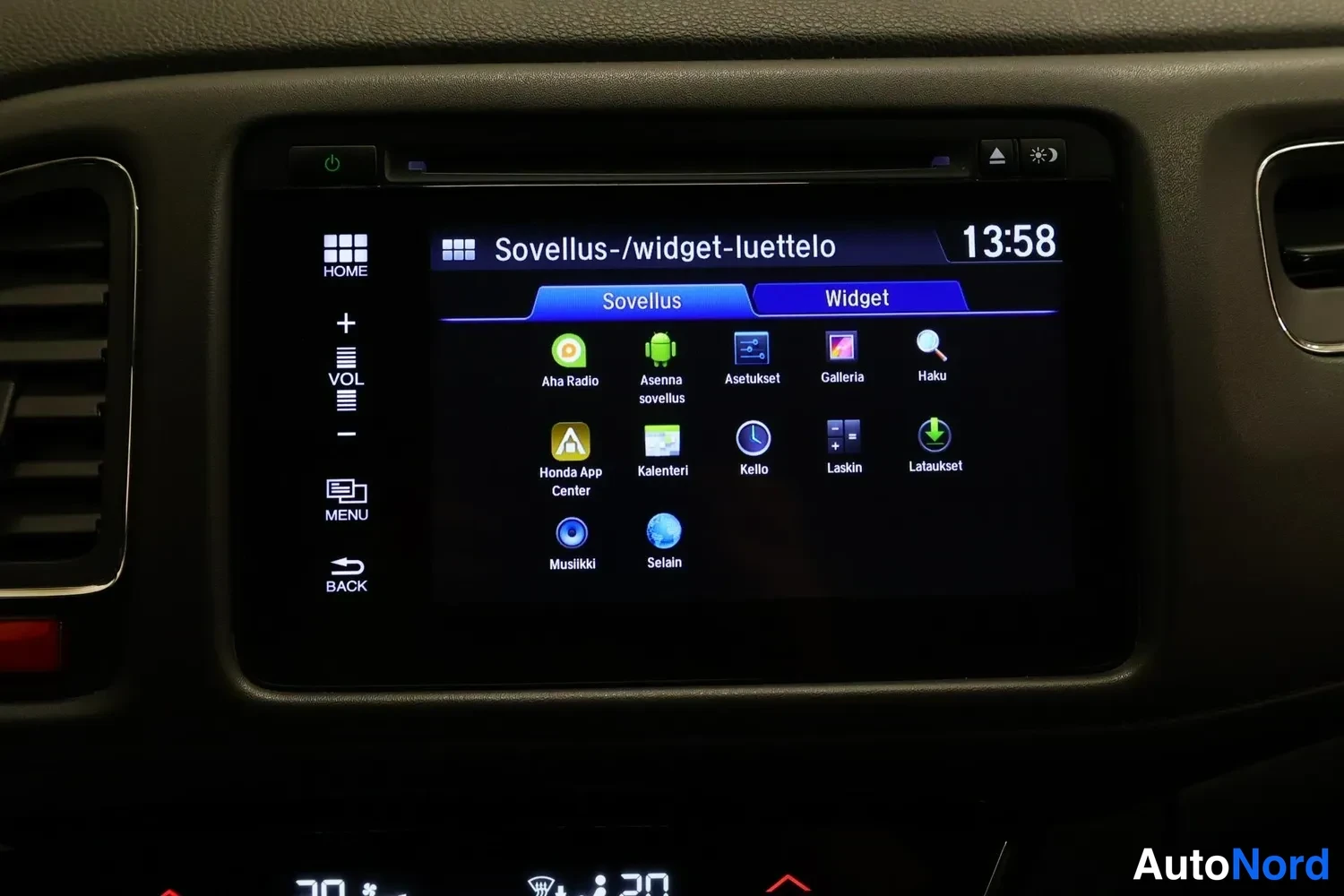 Yksityiskohta: Kosketusnäytön Sovellus-/widget-luettelo: Aha Radio, Asenna sovellus, Asetukset, Galleria, Haku, Honda App Center, Kalenteri, Kello, Laskin, Lataukset, Musiikki