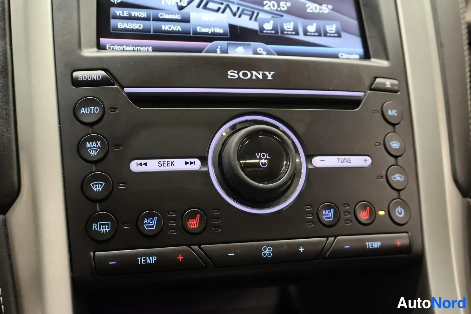 Yksityiskohta: Kojelaudan SONY-merkkinen radio- ja ilmastointipaneeli, jossa näkyvät lämmityspainikkeet ja Vol-osa.
