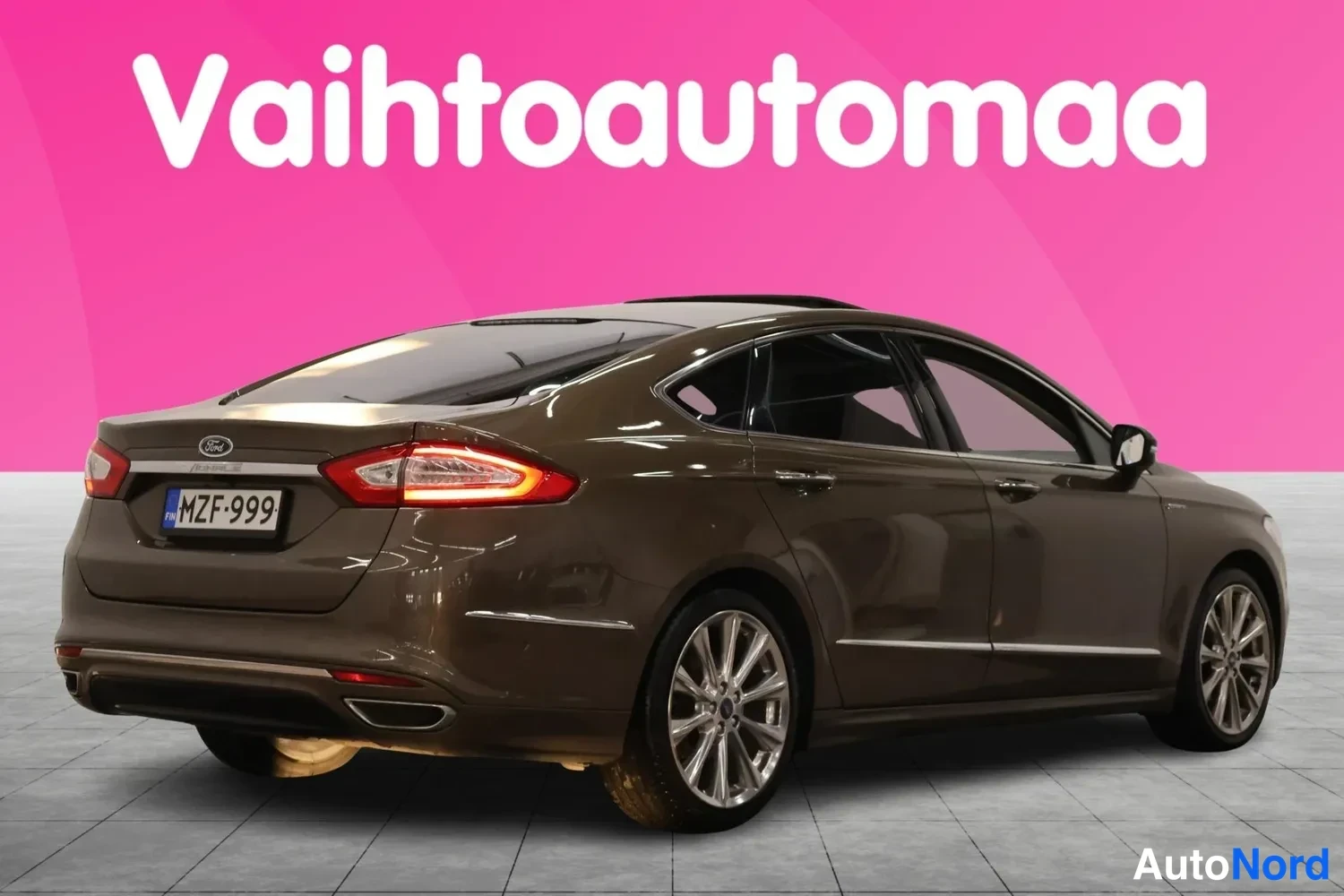 Takaviisto: Ruskean Ford Mondeo -sedanin takakulmanuvaus vasemmalta, oikea kylki ja konepelti näkyvät; rekisteritunnus.