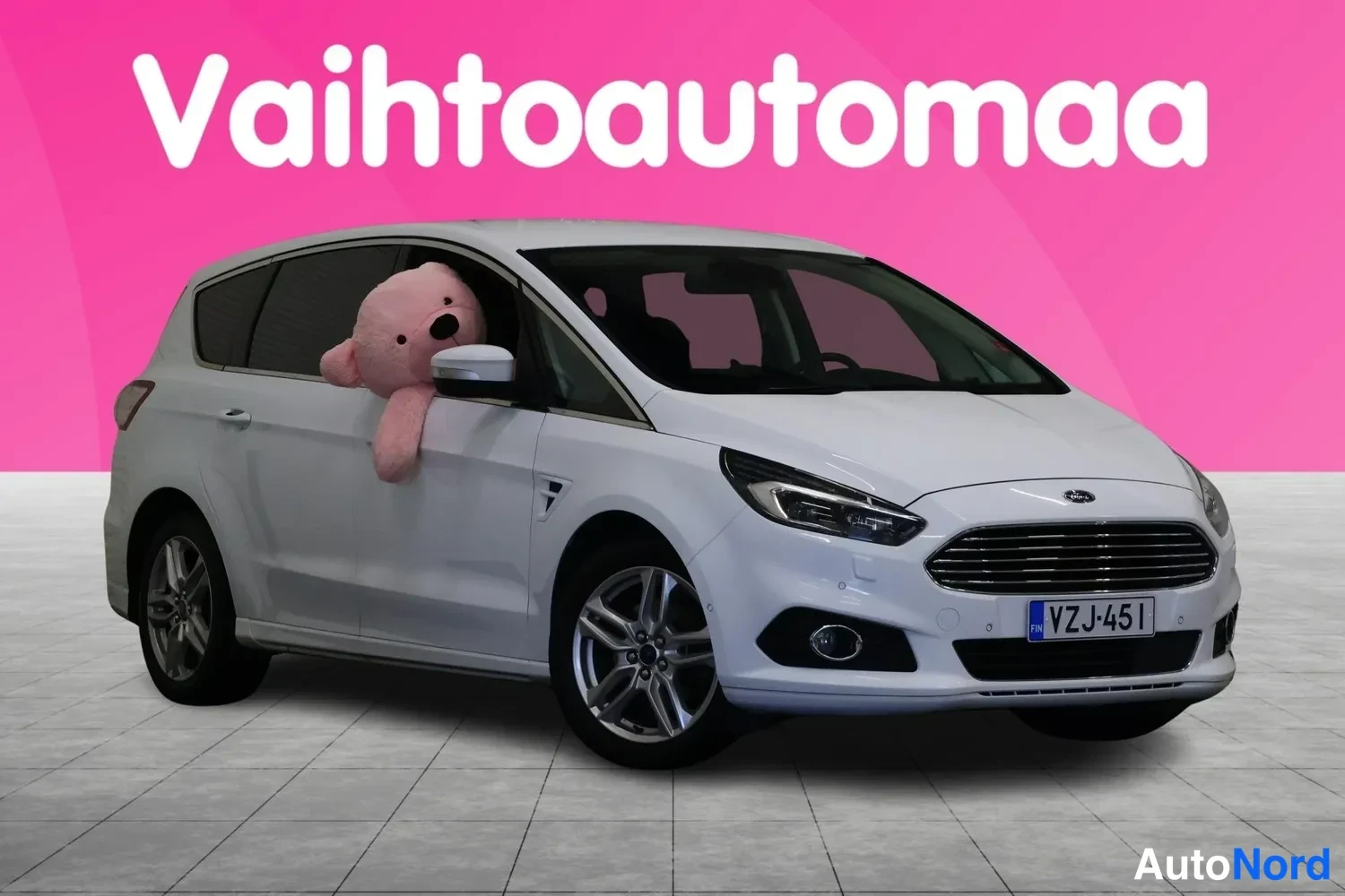 Etuviisto, nokka oikealle: Ford S-MAX, valkoinen farmarimallinen henkilöauto kolmella vanteella, etunurkku oikealta, rekisteritunnus.