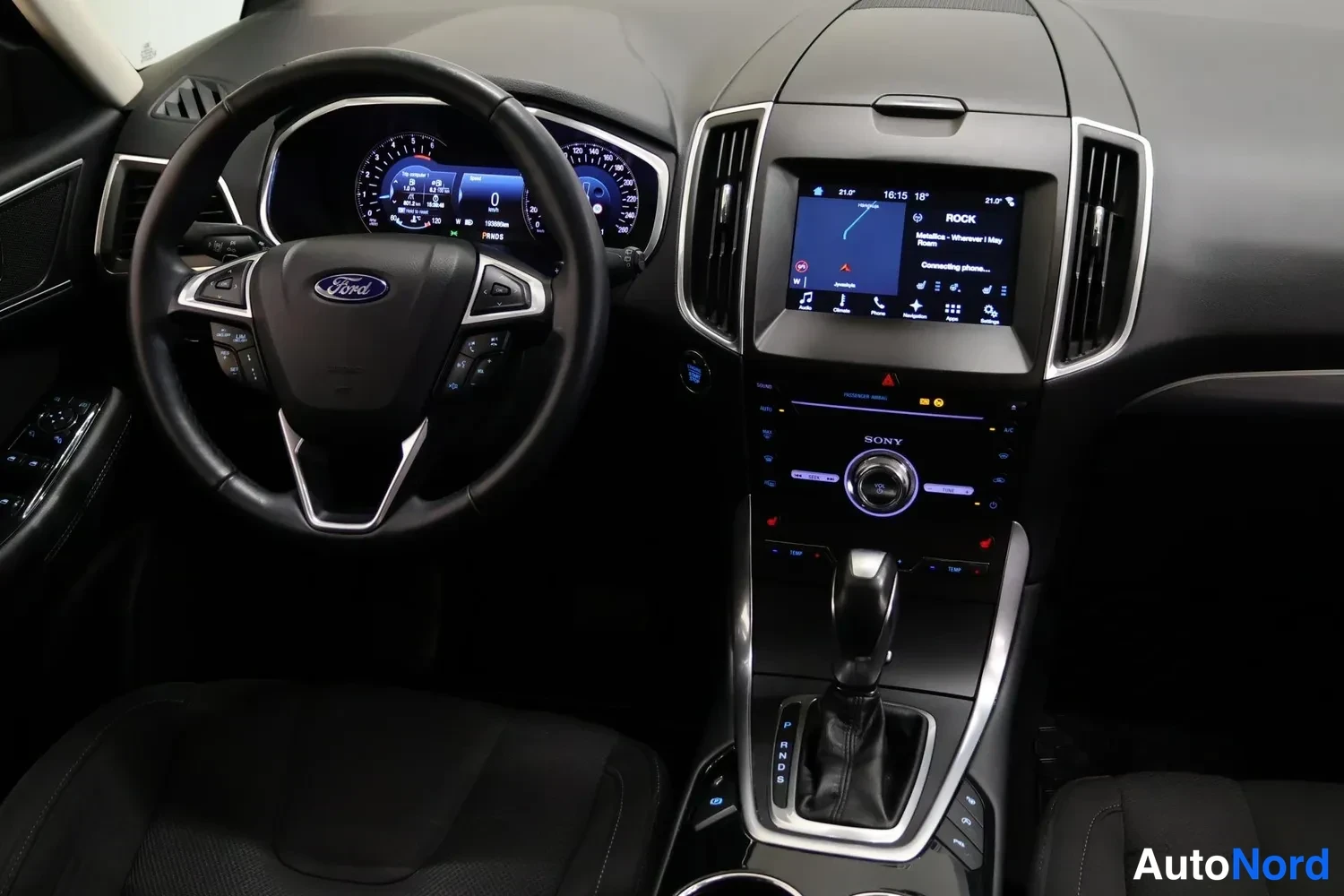 Edestä: Ohjaamo näkyy väliasennosta: Ford-ohjauspyörä, mittaristo, kosketusnäyttö, SONY-audio ja automaattivaihteen valitsin.