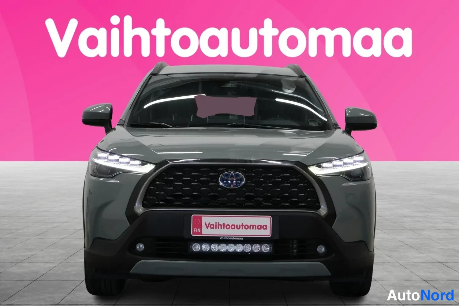 Edestä: Harmaan Toyota Corolla Crossin etunäkymä suoraan edestä.