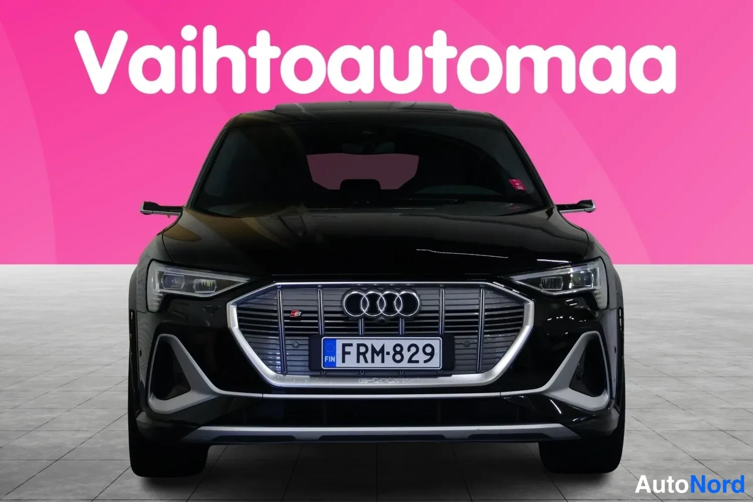 Edestä: Musta Audi suoraan edestä valokuvattu, rekisteritunnus.