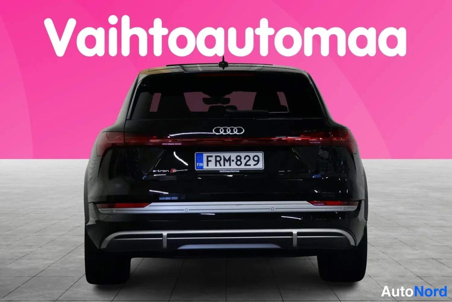Takaa: Musta Audi e-tron S suoraan takaa päin: punainen poikittain kulkeva takavalo, Audi-merkki ja rekisterikilpi.