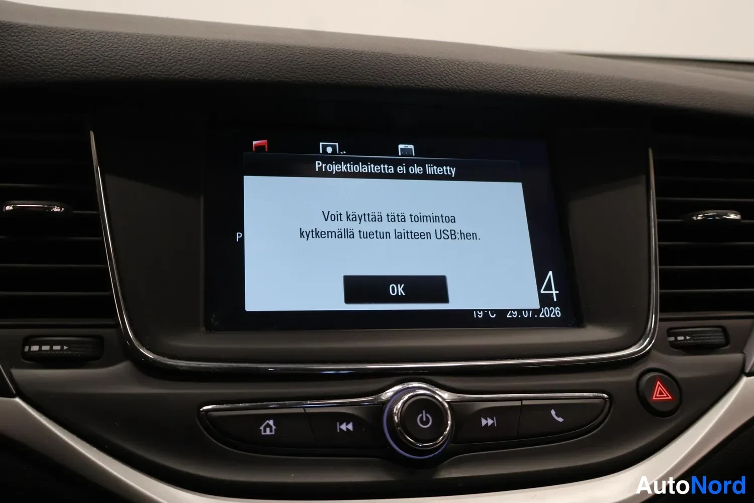 Yksityiskohta: Infotainment-näyttö joka kertoo 'Projektilaitetta ei ole liitetty' ja ohjeen tuetun laitteen kytkemisestä USB:hen.