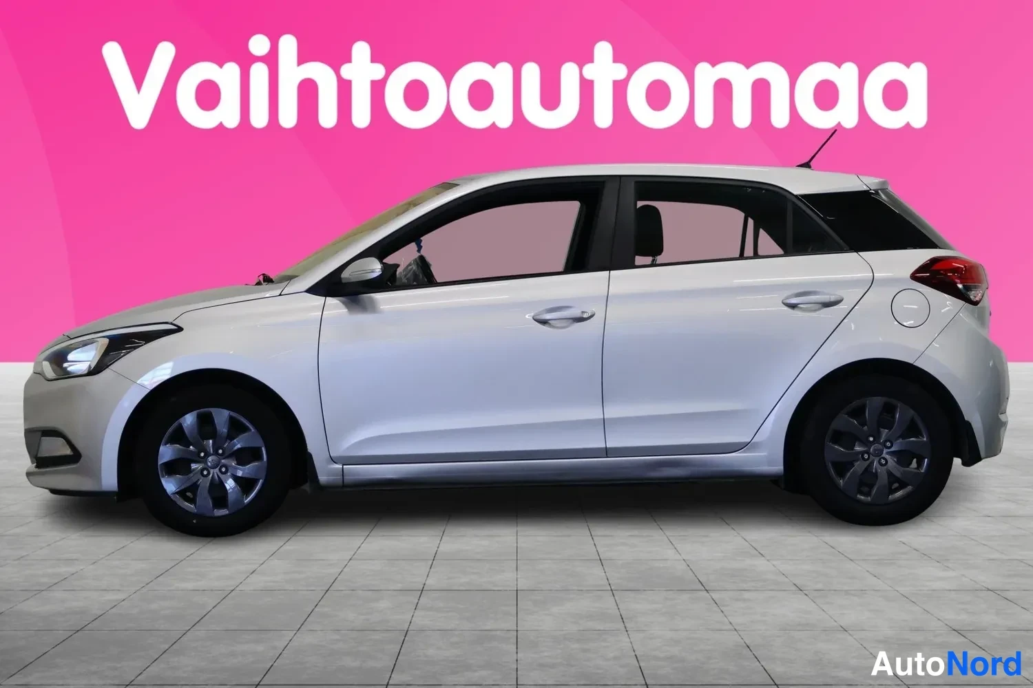 Sivulta: Hopeanharmaa Hyundai i20 -viistoperä sivulta vasemmalta katsottuna.