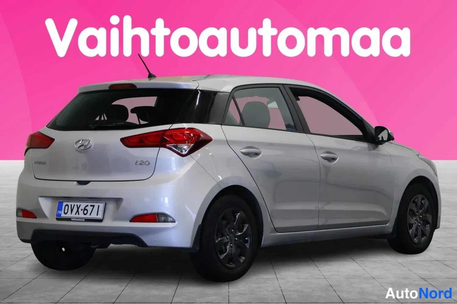 Takaviisto: Hopeanharmaa hatchback takaa-esta kuvattuna; takavalot, porttikoilu ja rekisterikilpi nakyvat, vasen kylki ja takapyorat osittain naamiovaa kuvassa.