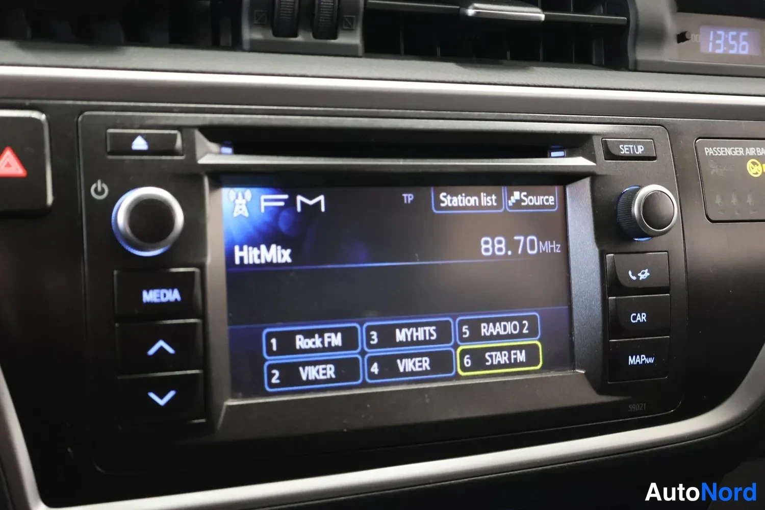 Yksityiskohta: Rstkonsolin näyttö ja painikkeet lähikuvassa; radio näyttää FM 88,70 MHz HitMixin ja asemalistan.