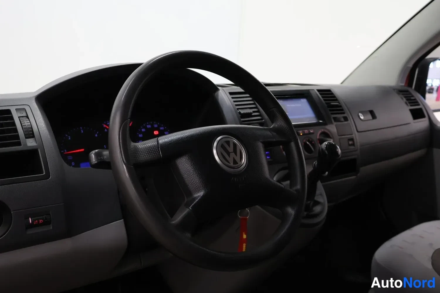Muu: Volkswagenin ohjaamo vasemmalta: ohjauspyörä, mittaristo, kosketusnäyttökojeisto ja käsivaihtaja, avaimen perä roikkuu kontaktissa.