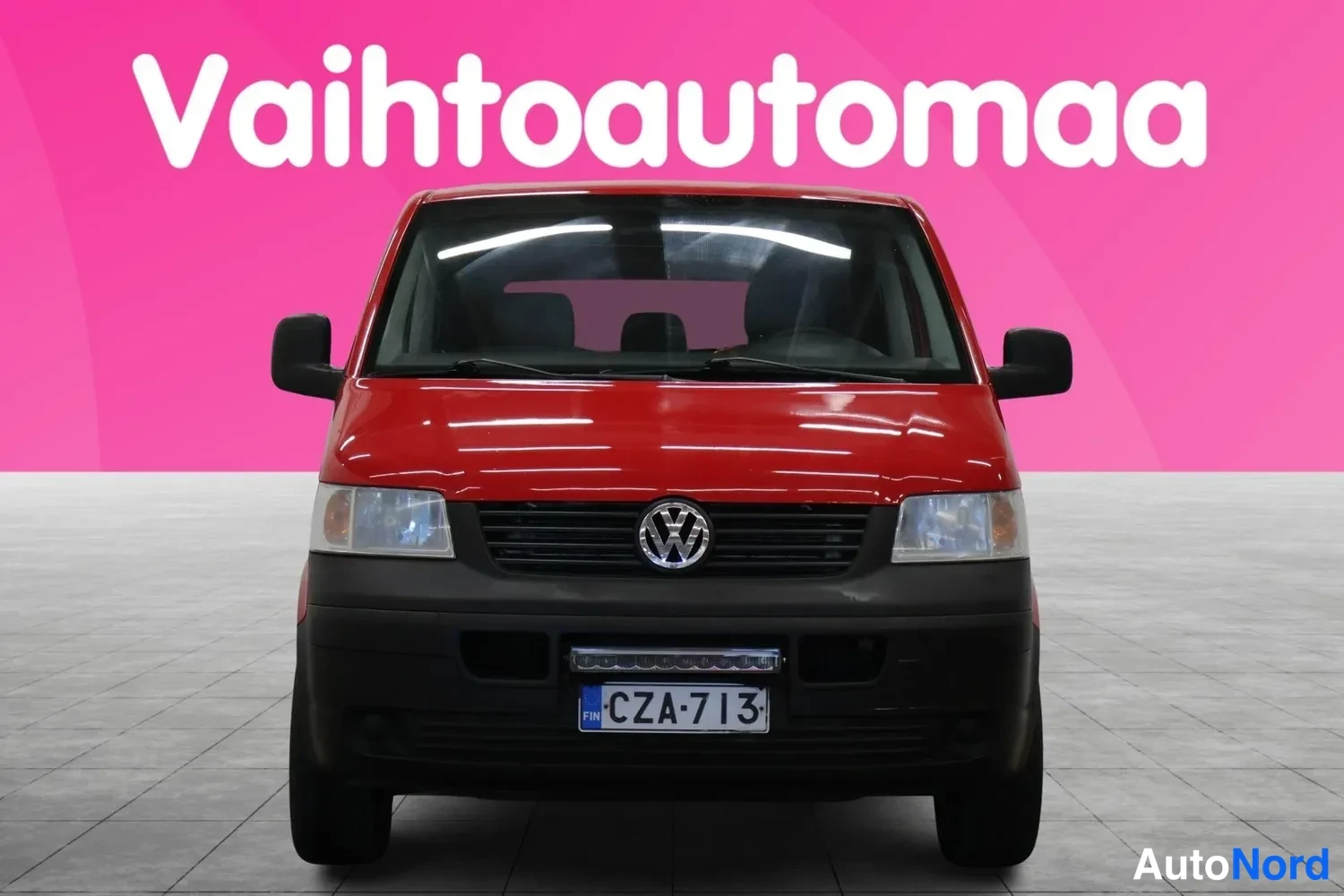 Edestä: Punainen Volkswagen Transporter suoraan edestä kuvattuna.