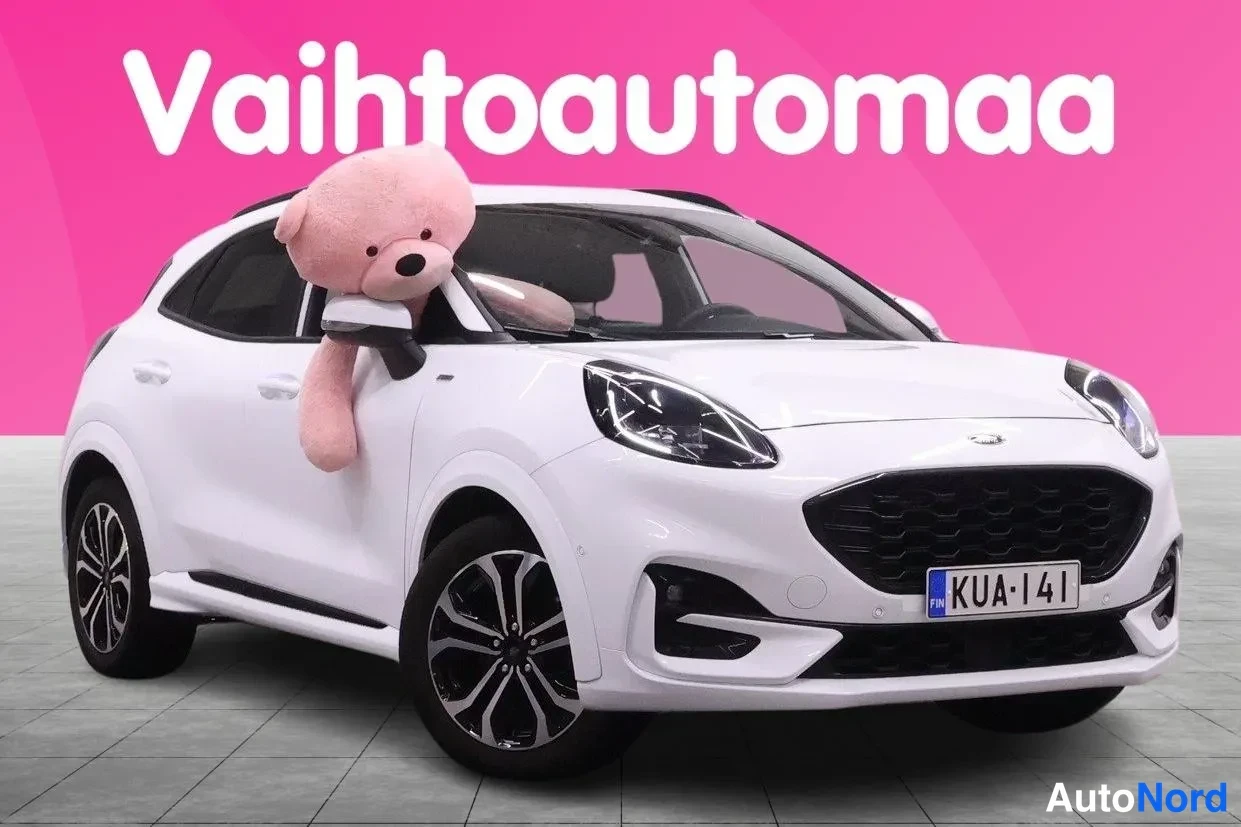 Etuviisto, nokka oikealle: Valkoinen Ford Puma etuosoittain oikealta, rekisteritunnus, pehmoâ€‹nÃ¤yttÃ¶ssÃ¤ ikkunassa.