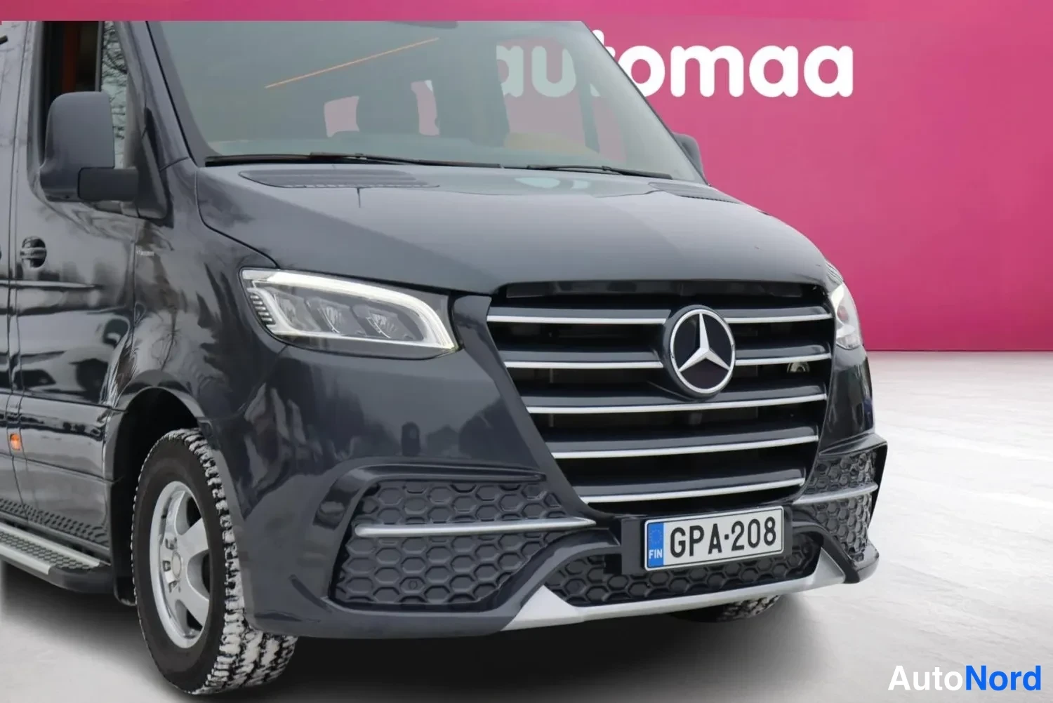Etuviisto, nokka oikealle: Mercedes-Benz Sprinterin etuosaa ja etukupea kolmannelta neljännekseltä, tummansininen kori, rekisterikilpi.