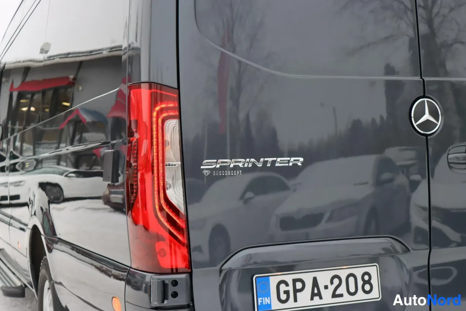 Takaa: Mercedes-Benz Sprinterin takaosan lähihöinät, punainen taka valo, Sprinter-logo ja rekisterikilpi.