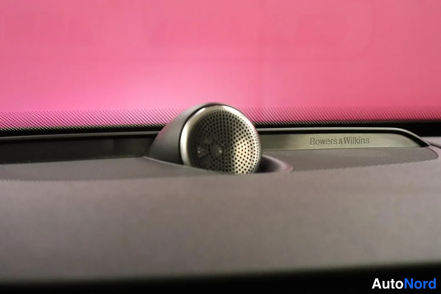 Yksityiskohta: Kojelaudan keskellä kierretyllä jalustalla oleva diskanttikaiutin, viereisessä listassa teksti 'Bowers & Wilkins'.