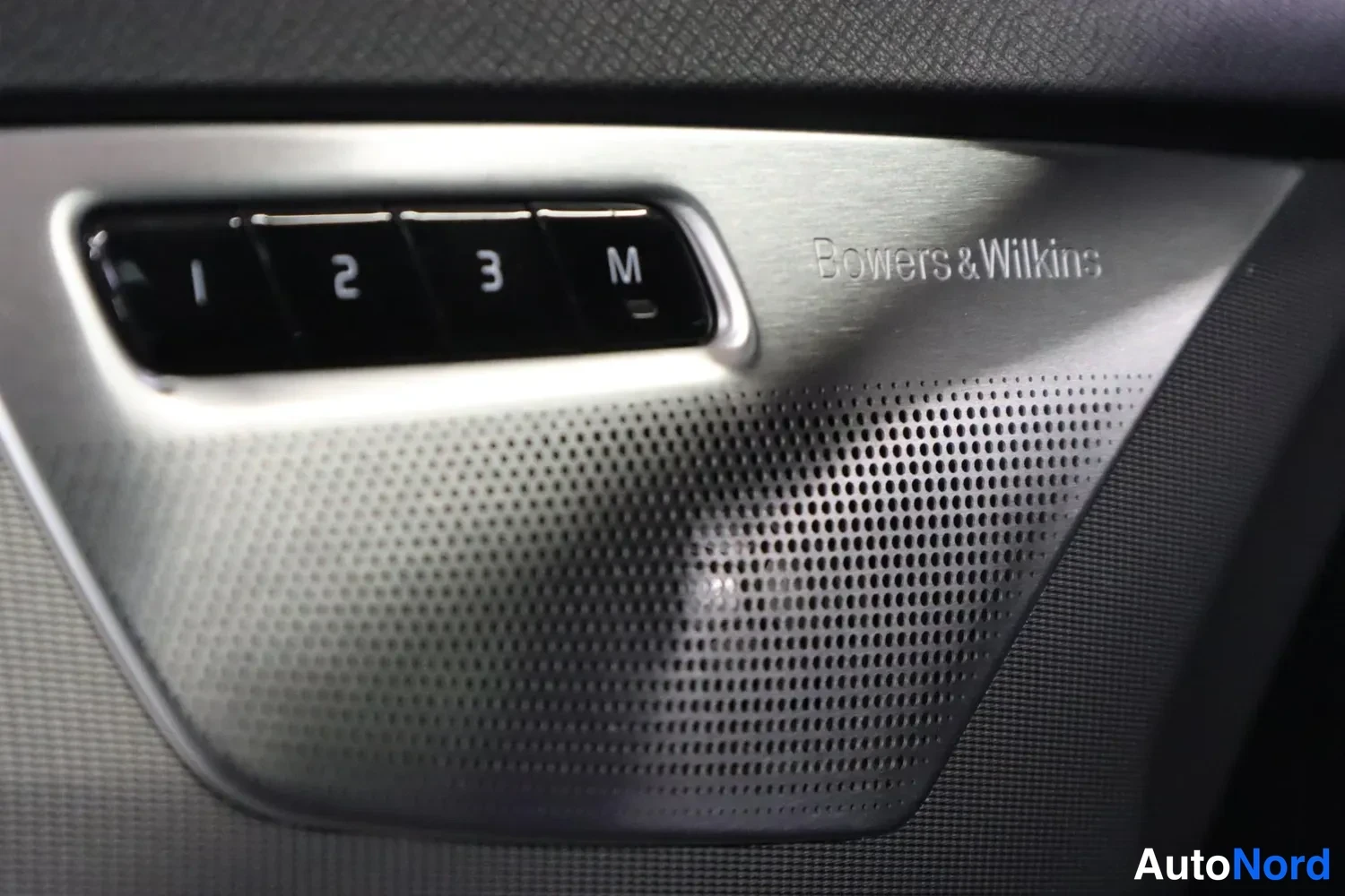 Yksityiskohta: Oven paneelissa muistipainikkeet 1, 2, 3 ja M sekä Bowers & Wilkins -merkitty kaiutinverkko.