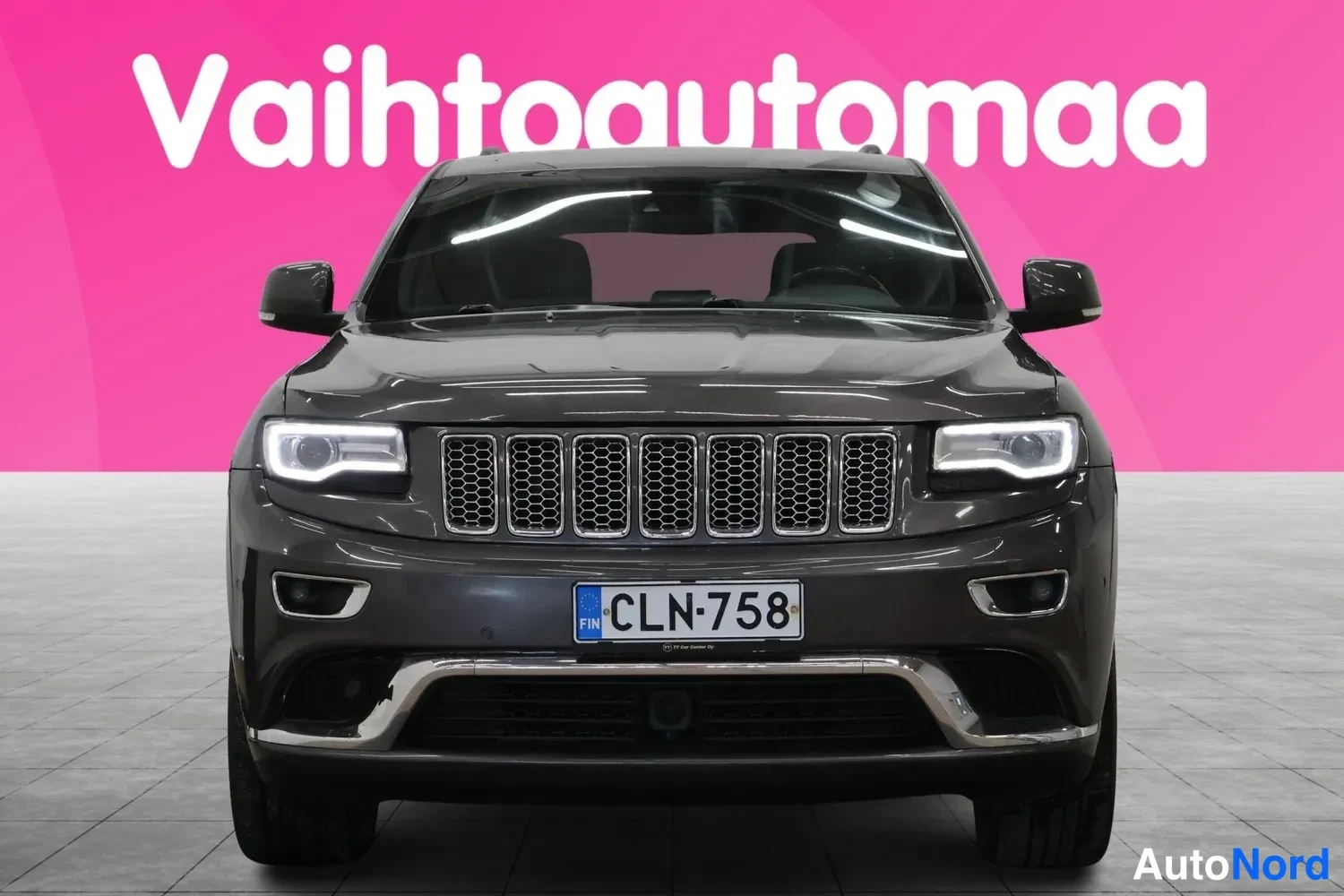 Edestä: Jeep Grand Cherokee suoraan edestä päin; tumma kori, kromikehystetty etusäleikkö, LED-ajovalot ja rekisterikilpi (FIN).