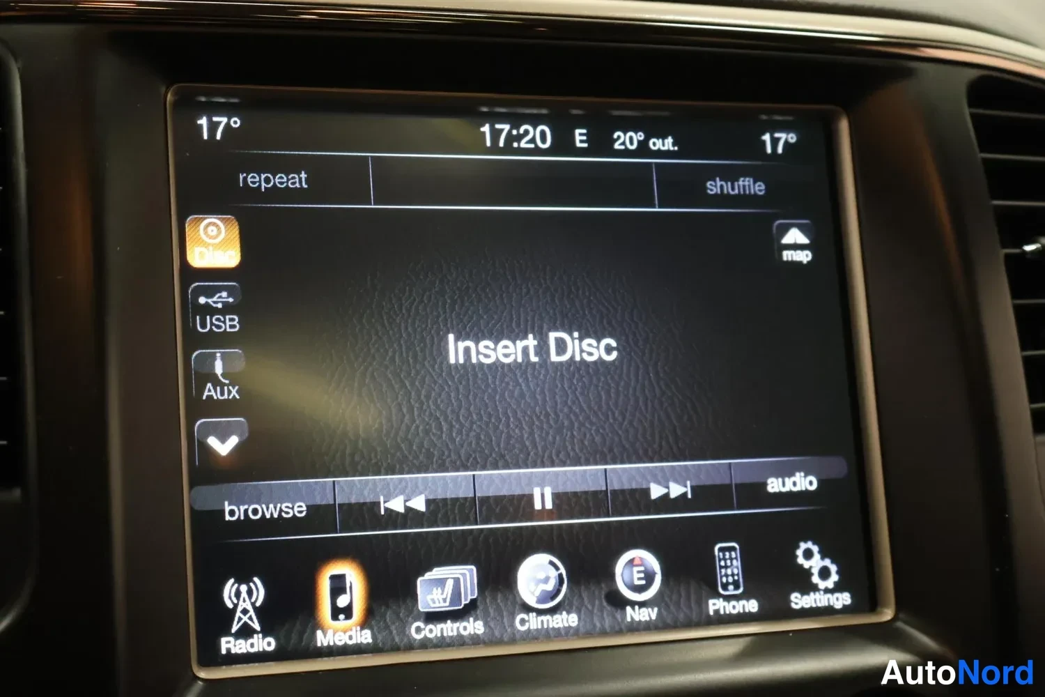 Yksityiskohta: Radiopaneelin kosketusnäyttö musiikkinäytöllä, teksti 'Insert Disc', valikot Radio, Media, Controls, Climate, Nav, Phone ja Settings.