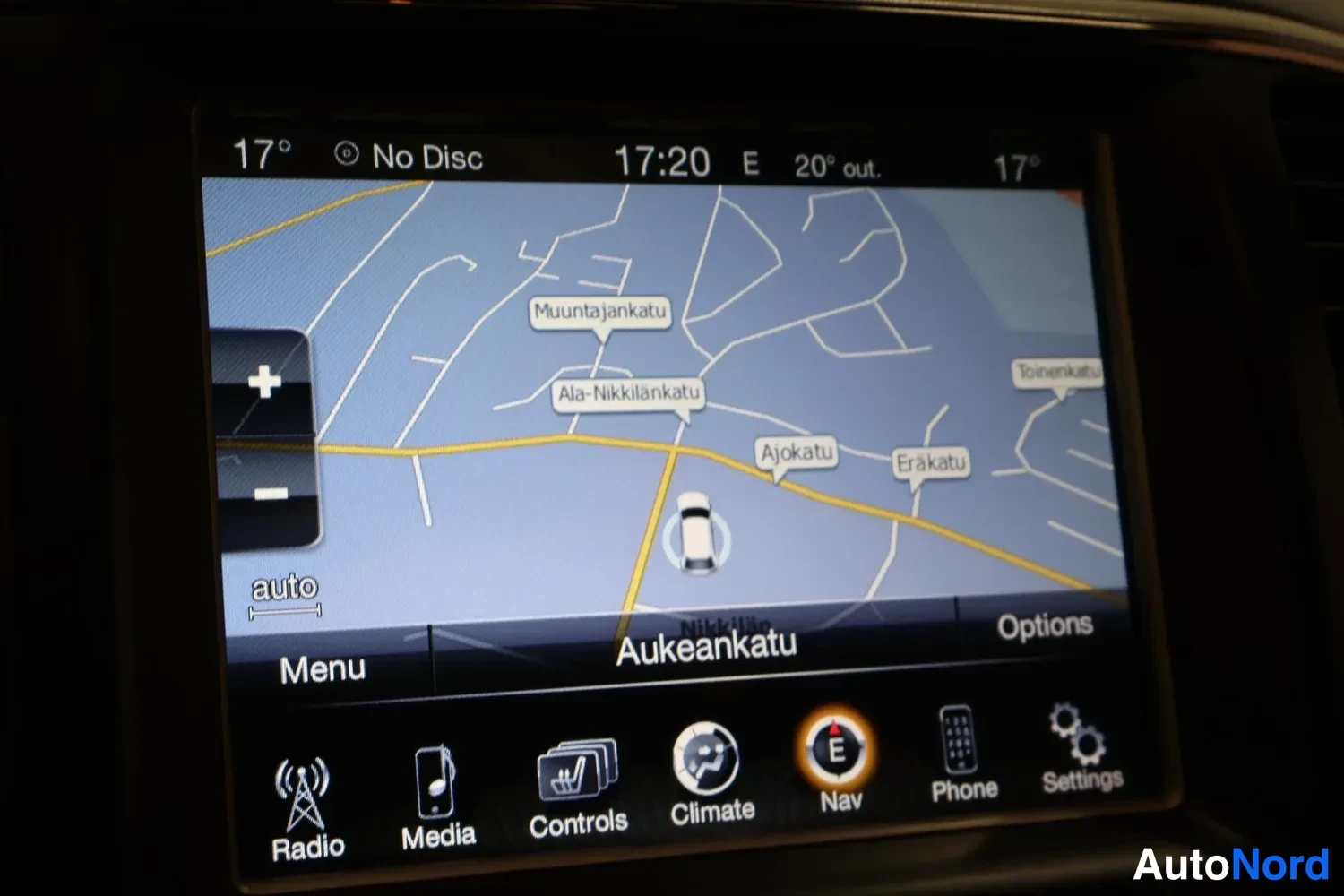 Yksityiskohta: Auton infotainment-näytöllä näkyy navigaatiokartta, jossa on paikannimiä kuten Muuntajankatu ja Ala-Nikkilänkatu, alareunassa Radio-, Media-, Controls-, Climate