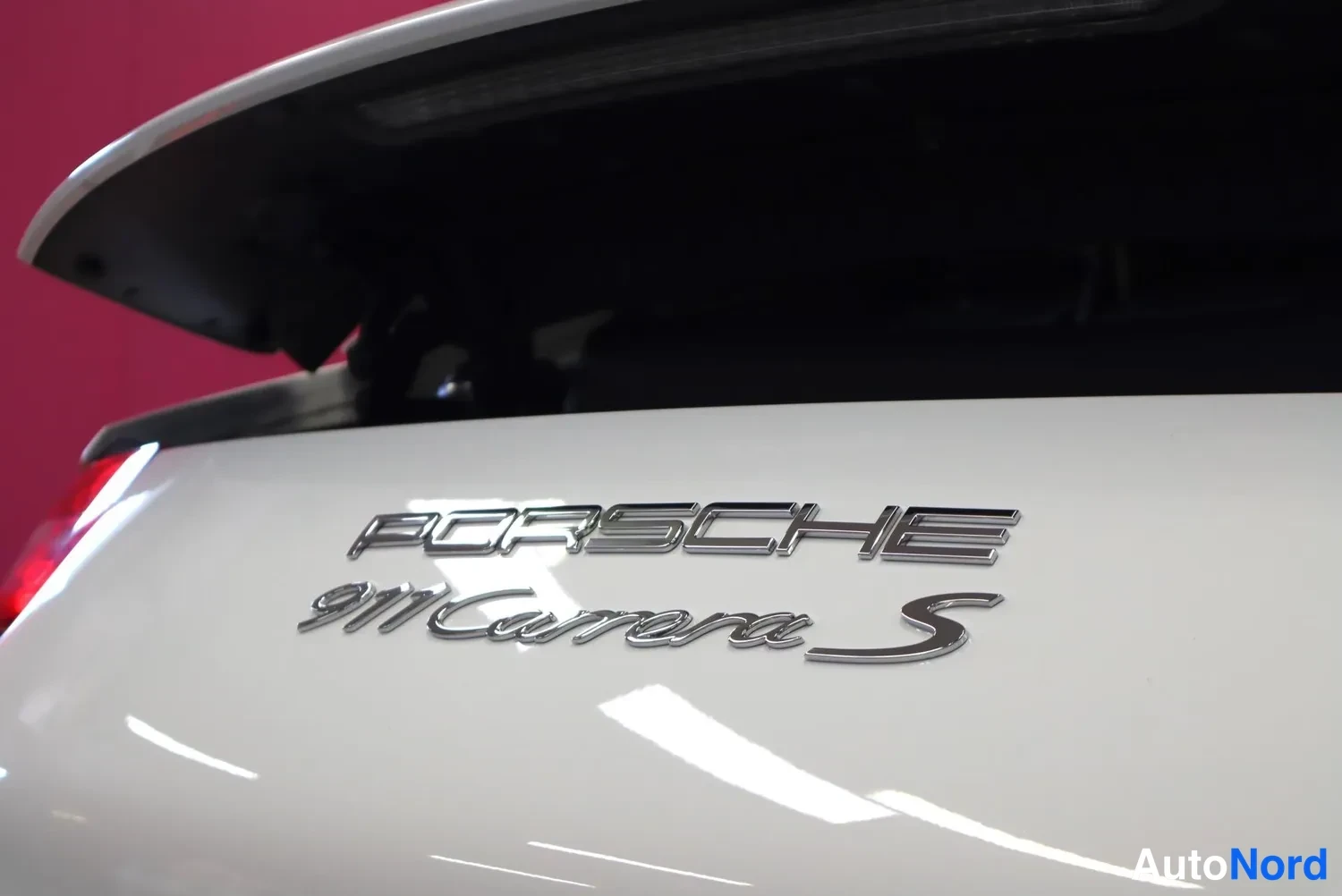 Takaa: Valkoisen Porsche 911 Carrera S -mallin takakansi, chromattu PORSCHE- ja 911 Carrera S -merkintä näkyvissä.