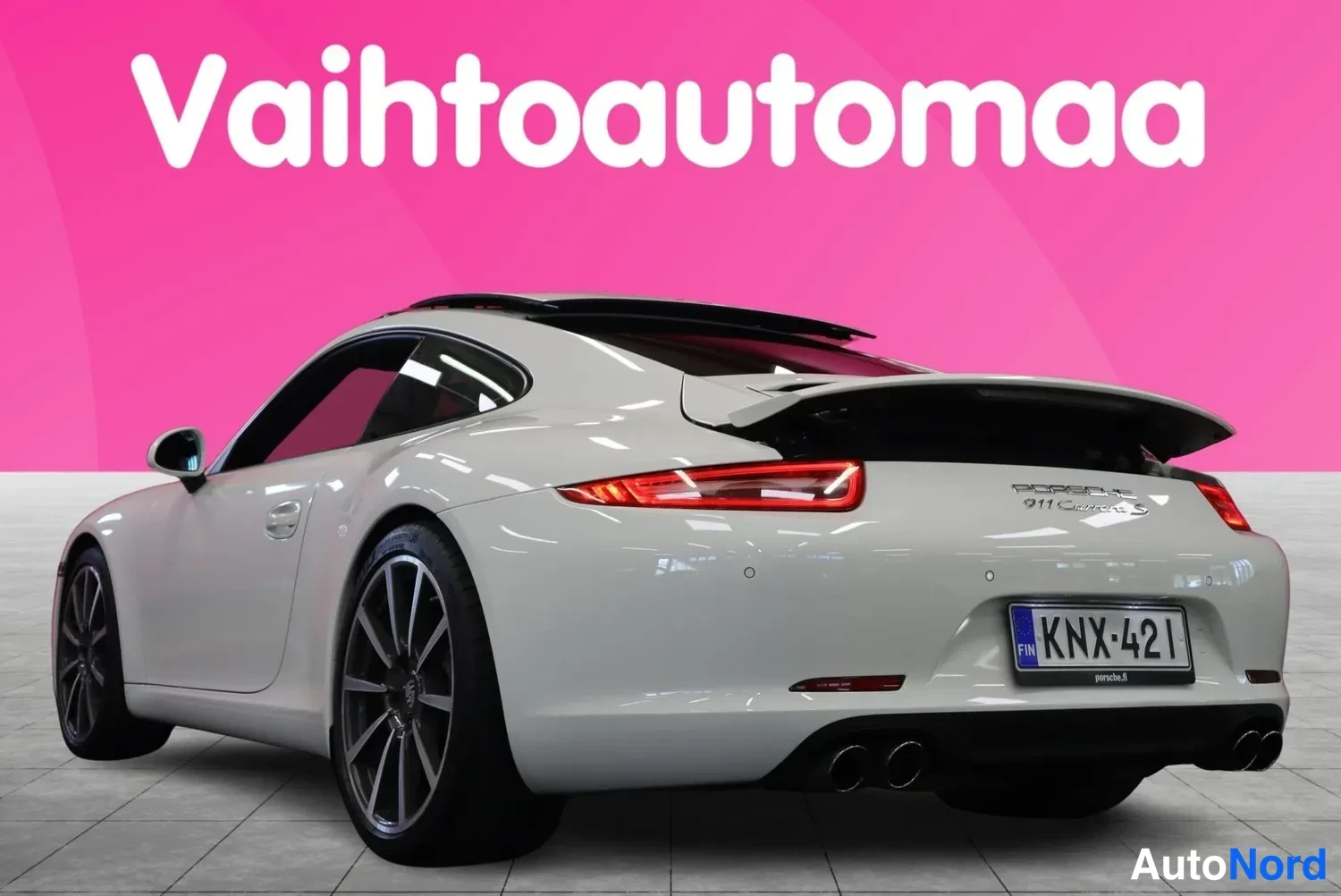 Takaviisto: Porsche 911 Carrera S -auton takakulma vasemmalta, valkoinen kori, kaksoispakoputket ja -kilpi.