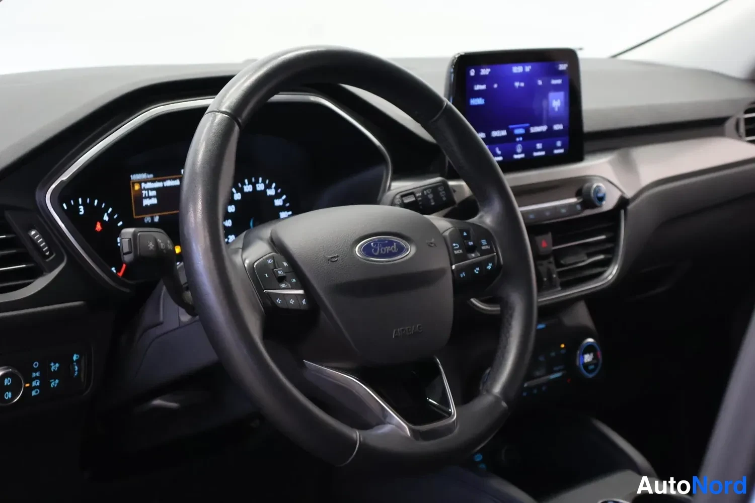 Muu: Kuljettajan näkymä ohjauspyörään Ford-logolla, mittaristo ja keskinäyttö näkyvät.