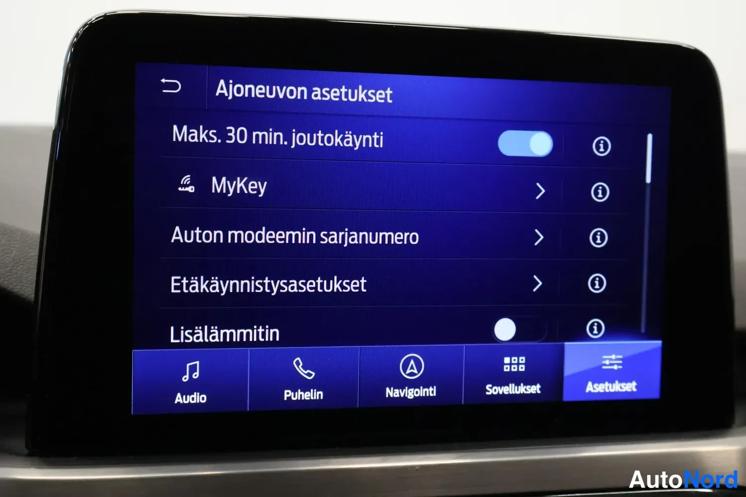 Muu: Auton keskusnäytön Ajoneuvon asetukset -valikko, jossa kohdat Maks. 30 min. joutokäynti, MyKey, Auton modeemin sarjanumero, Etäkäynnistyasetukset ja Lisälämmiti