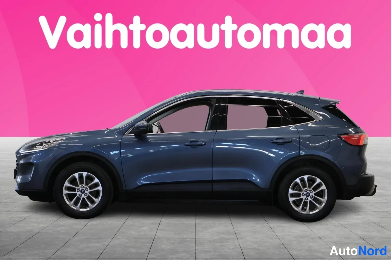 Etuviisto, nokka vasemmalle: Sininen Ford Kuga -maastauto kolmannelta osalta, keula vasemmalla.