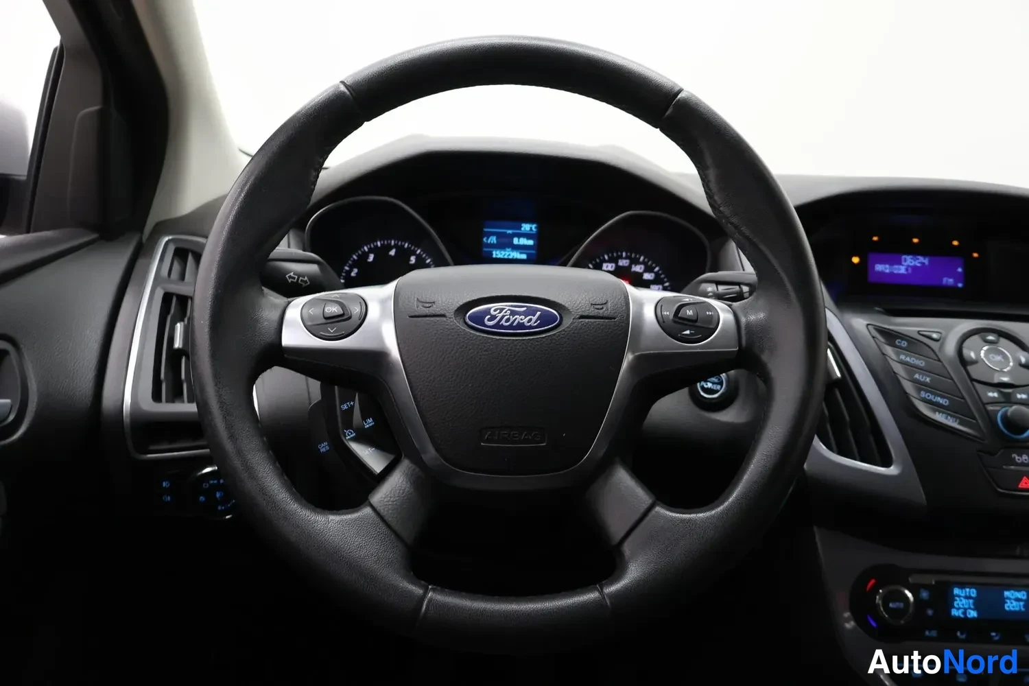 Muu: Ohjauspyörä ja kojetaisti lähikuvassa; mittaristo näkyvissä, Ford-merkki keskellä.