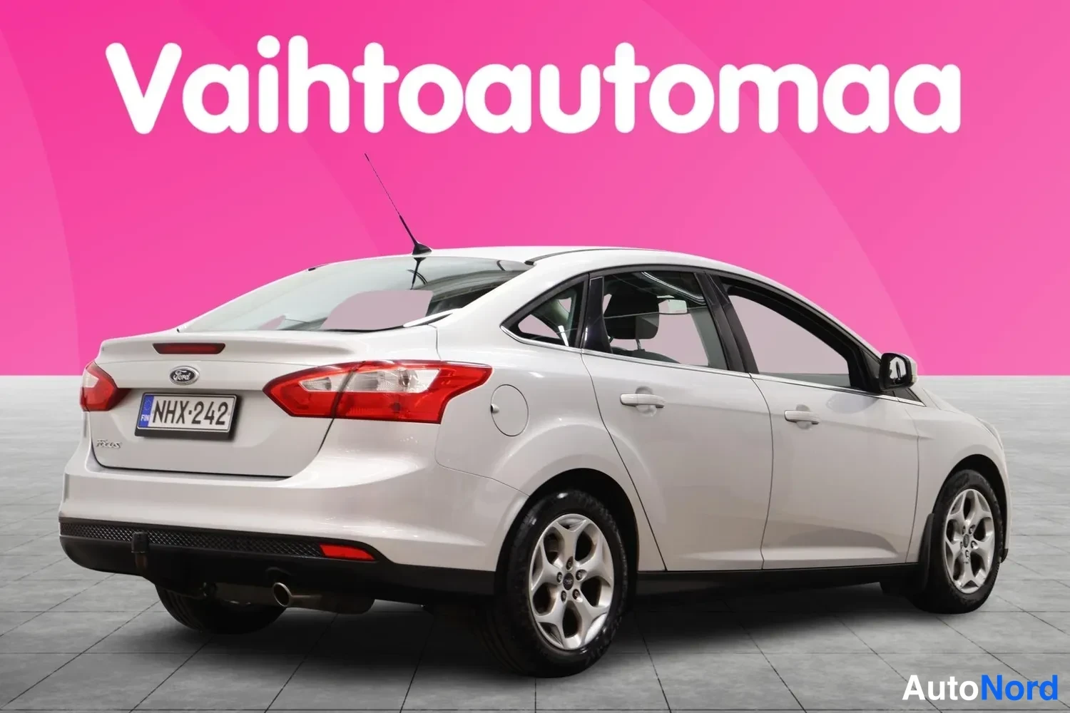 Takaviisto: Hopeanvärinen Ford Focus -porasäädin takaa viistosti vasemmalta, rekisteritunnus.