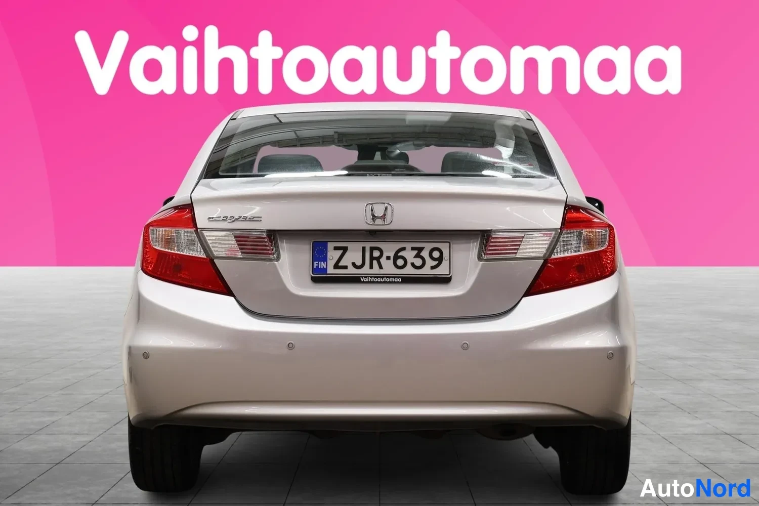 Takaa: Hopeanharmaan Honda Civicin takaosa suoraan takaa; takavalot ja rekisterikilpi näkyvät.